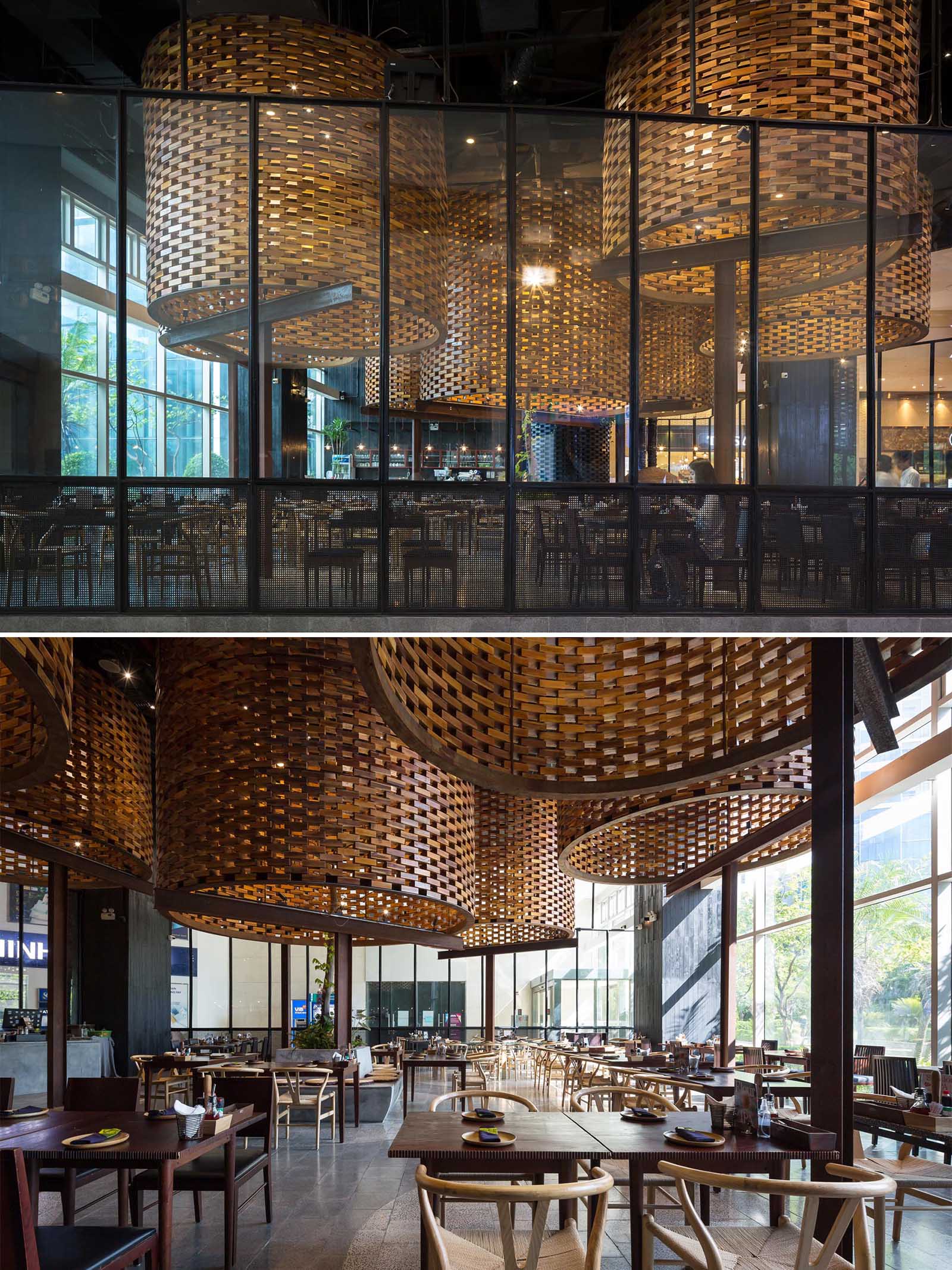 A modern restaurant with large sculptural cylinders made from wood bricks.