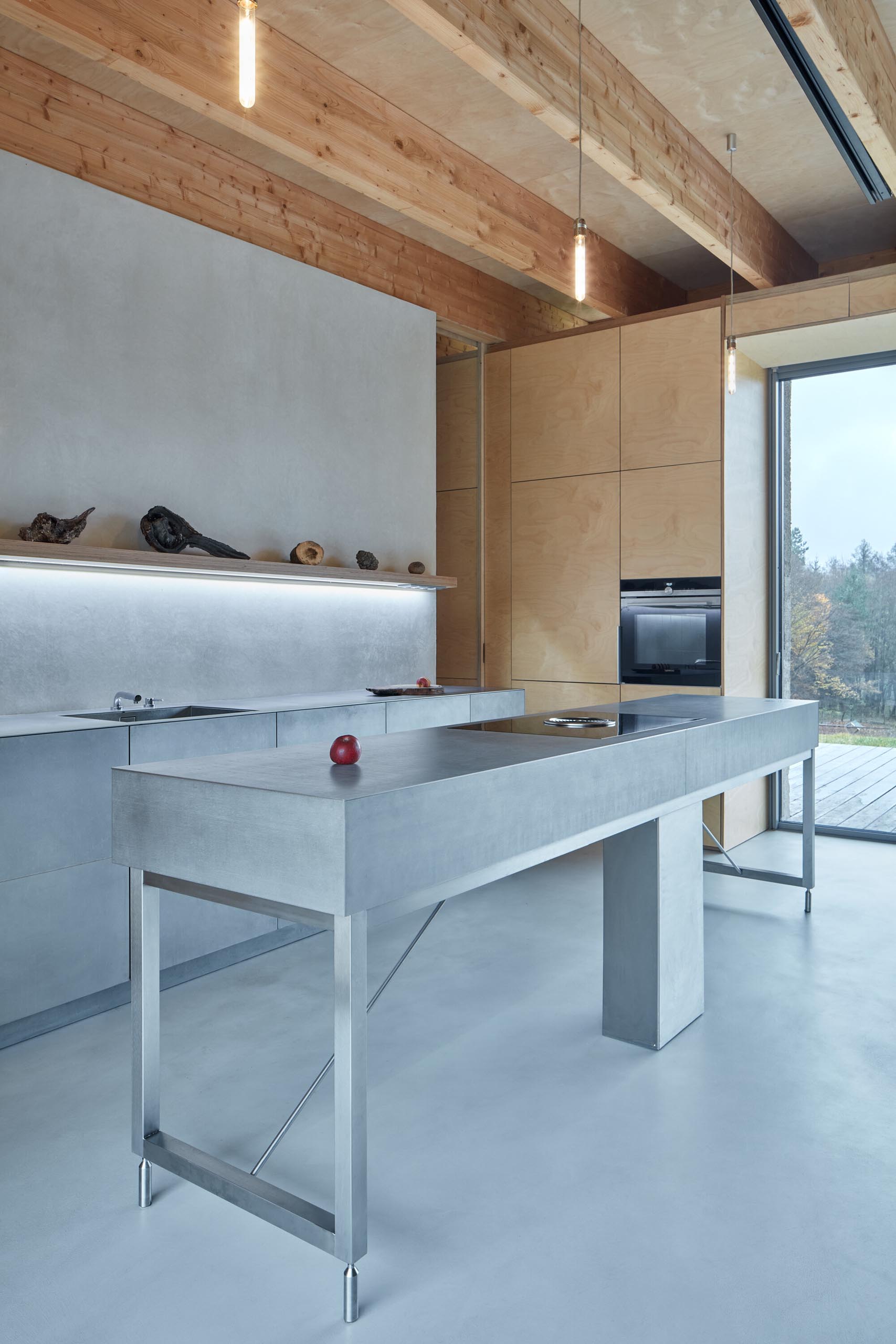 Inside this modern cabin there's an open plan dining room and kitchen, with the stainless steel kitchen standing out in the mostly wood interior.