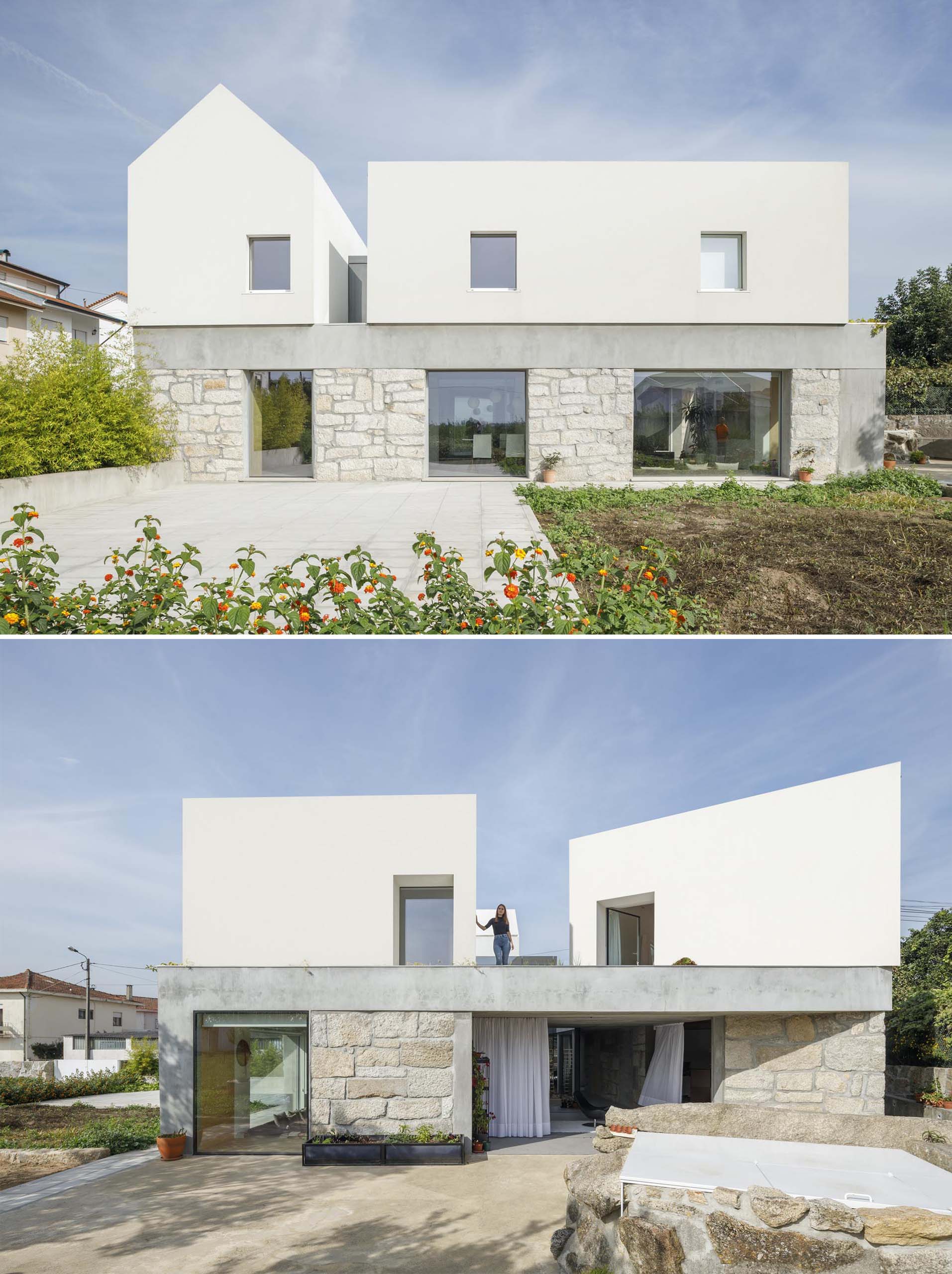 A modern home with stone walls, and a white upper floor.
