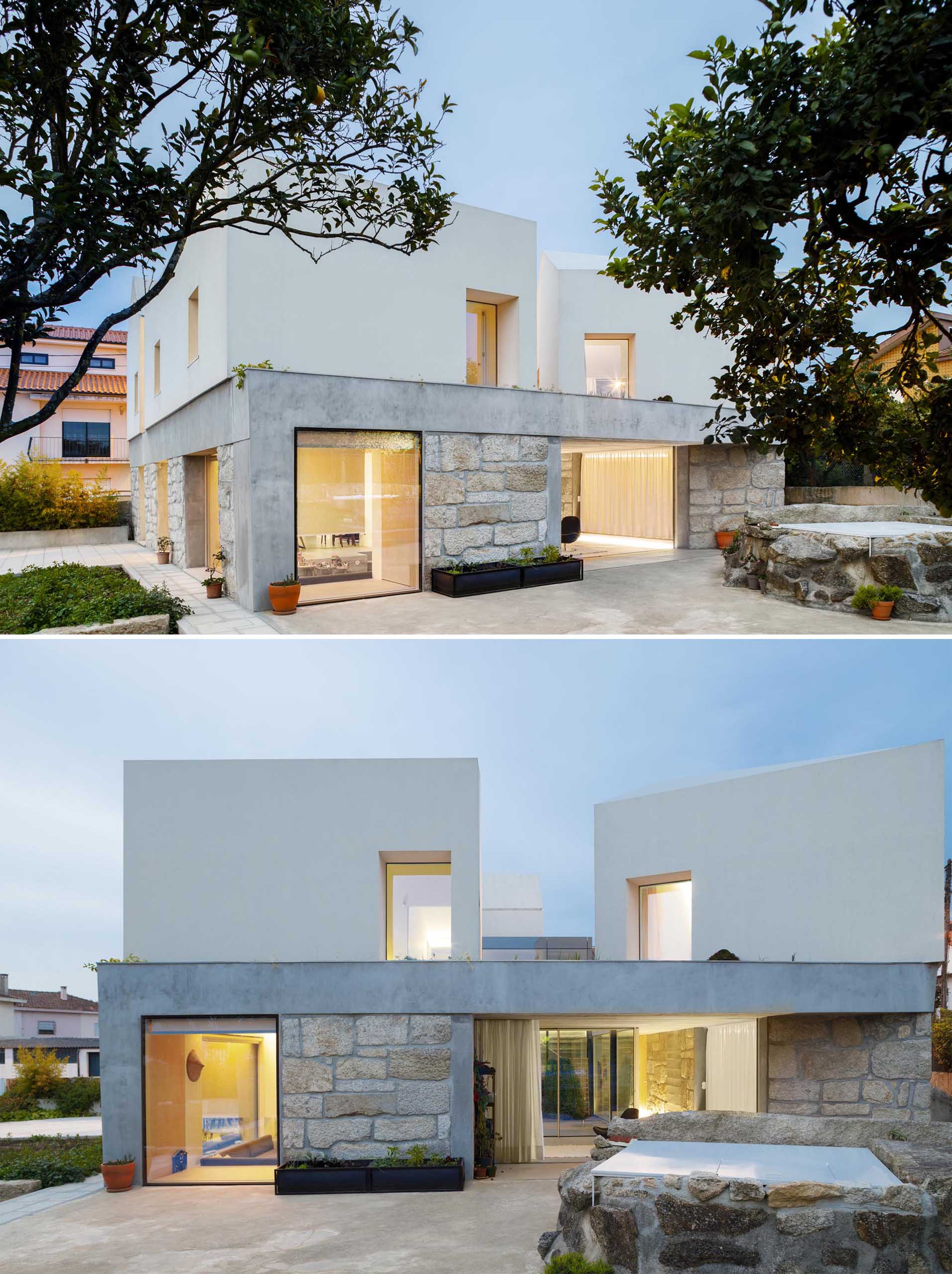 A concrete slab separates the stone walls and white upper portion of this modern home.