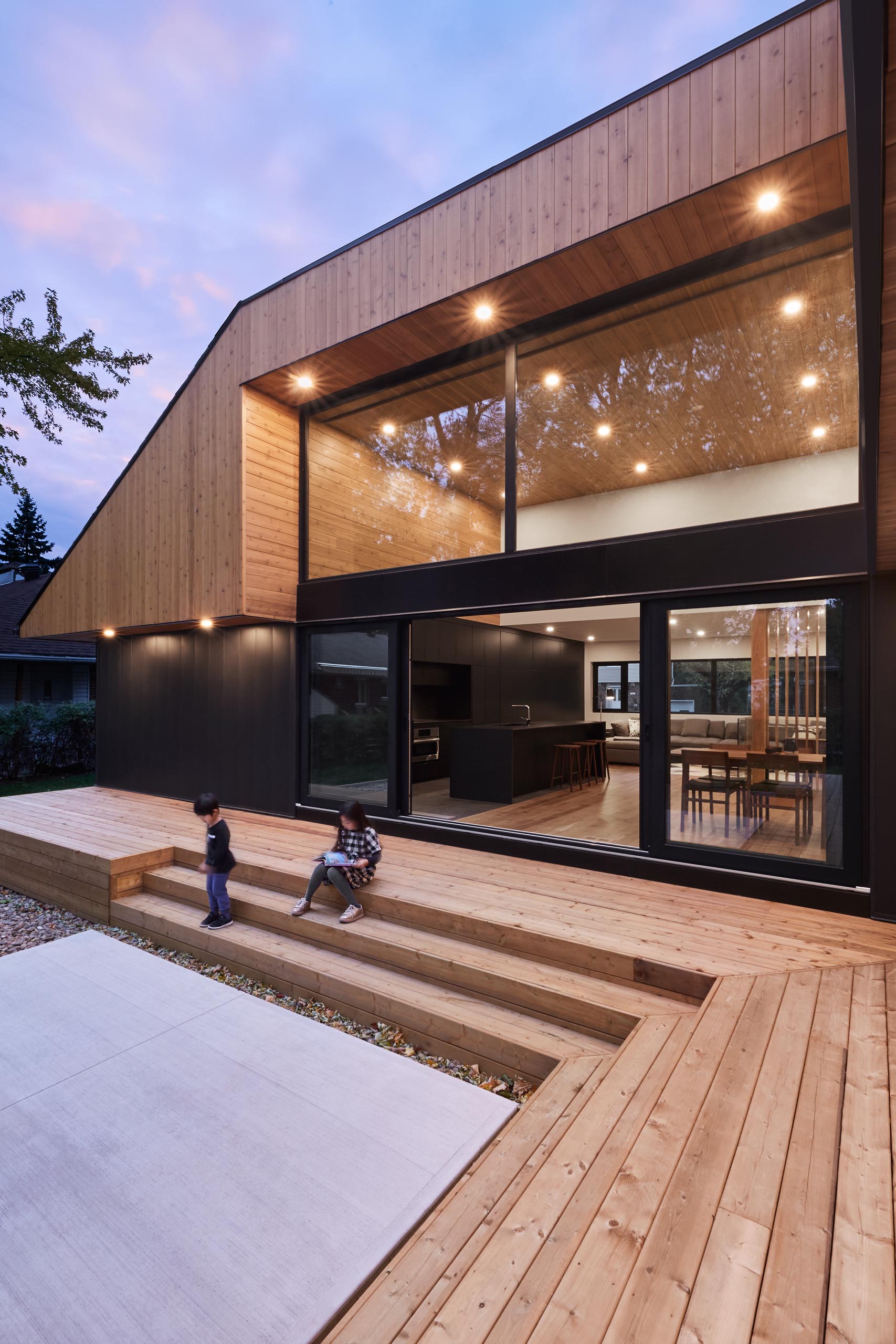 A modern home with high ceilings, and a black framed sliding lass door.