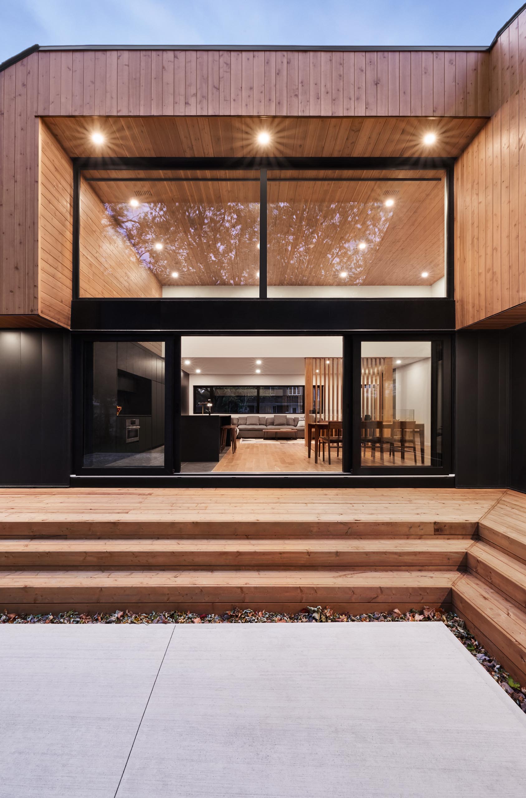 A modern home with high ceilings, and a black framed sliding lass door.