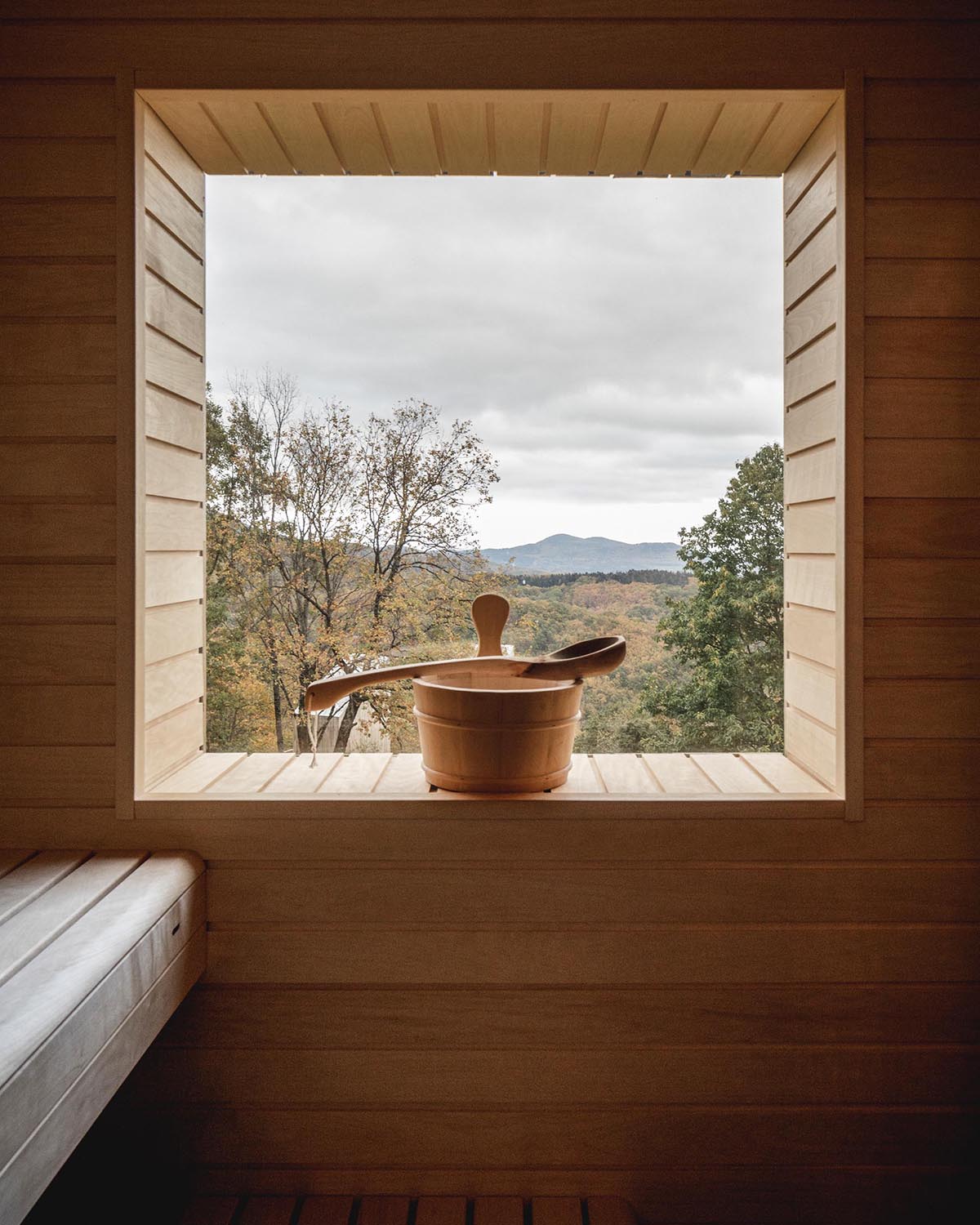 A modern sauna with built-in furniture and light wood interior.