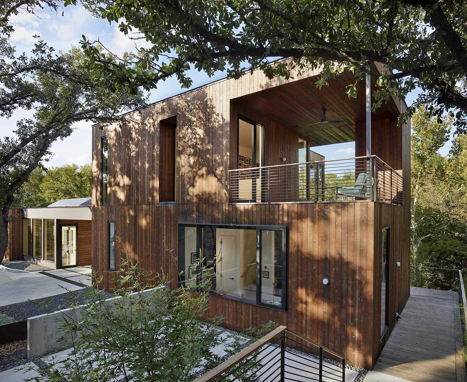 A modern home addition with a green roof and a wrap-around deck.