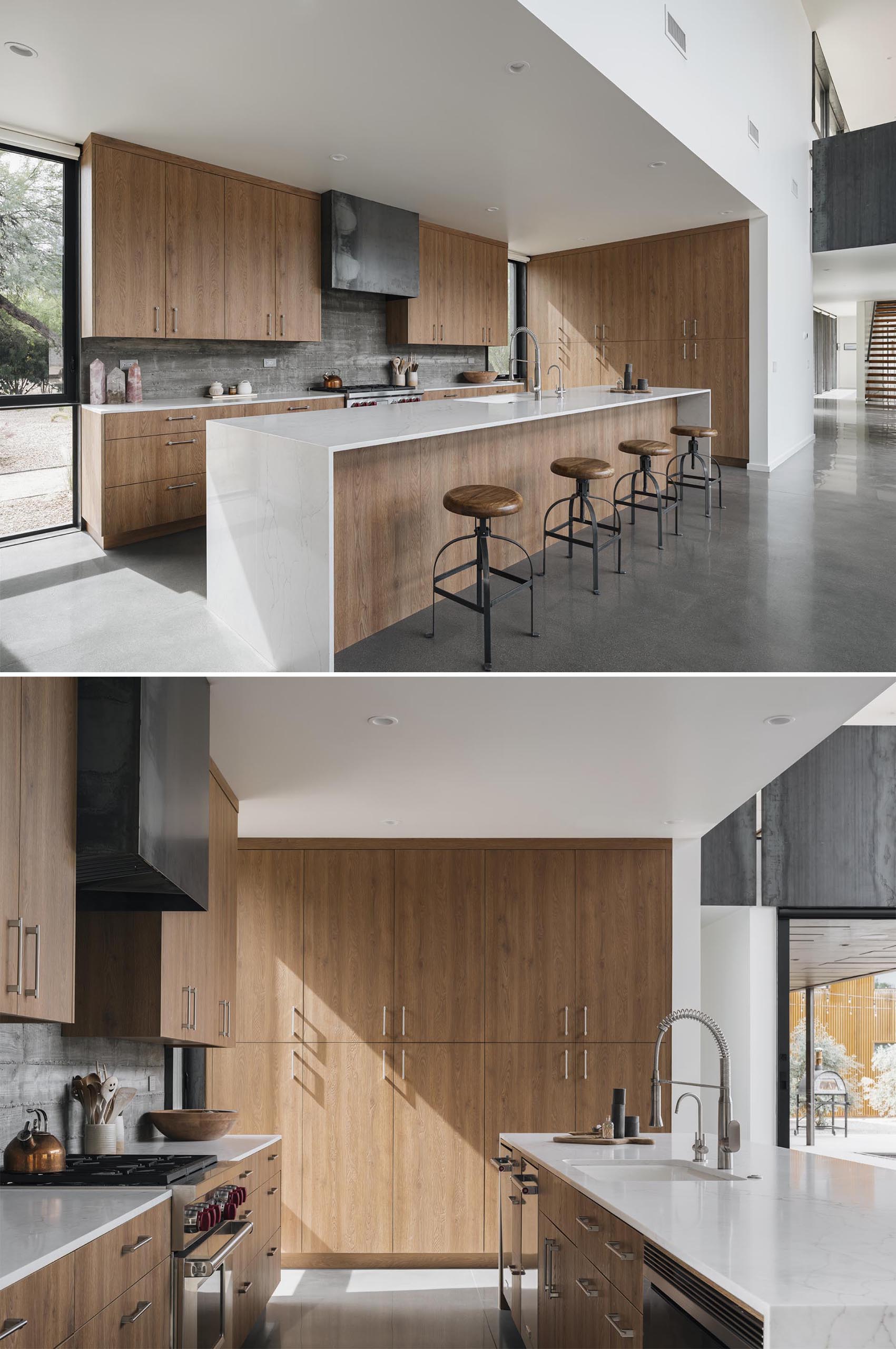 The wood cabinetry in the kitchen has been installed right up against the board-formed concrete wall, while a long kitchen island creates plenty of counter space.