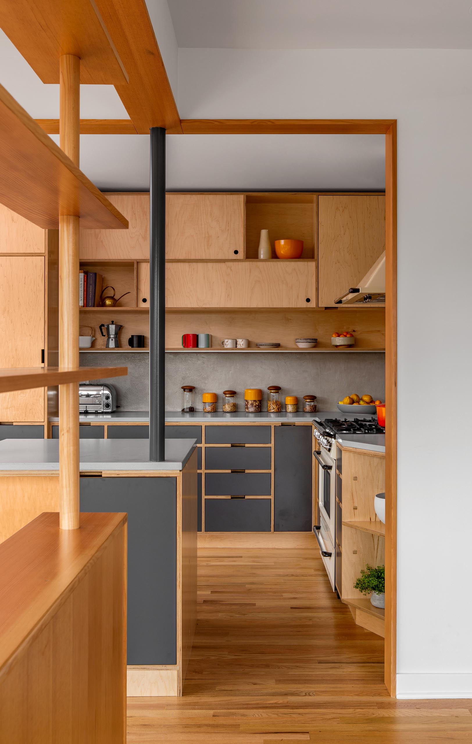 A modern custom-designed kitchen with wood and gray cabinets.