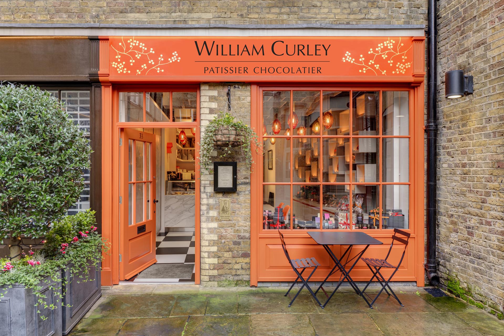 A modern chocolatier with a vivid orange facade that draws inspiration from the lid of the boxes the chocolates are packaged in.