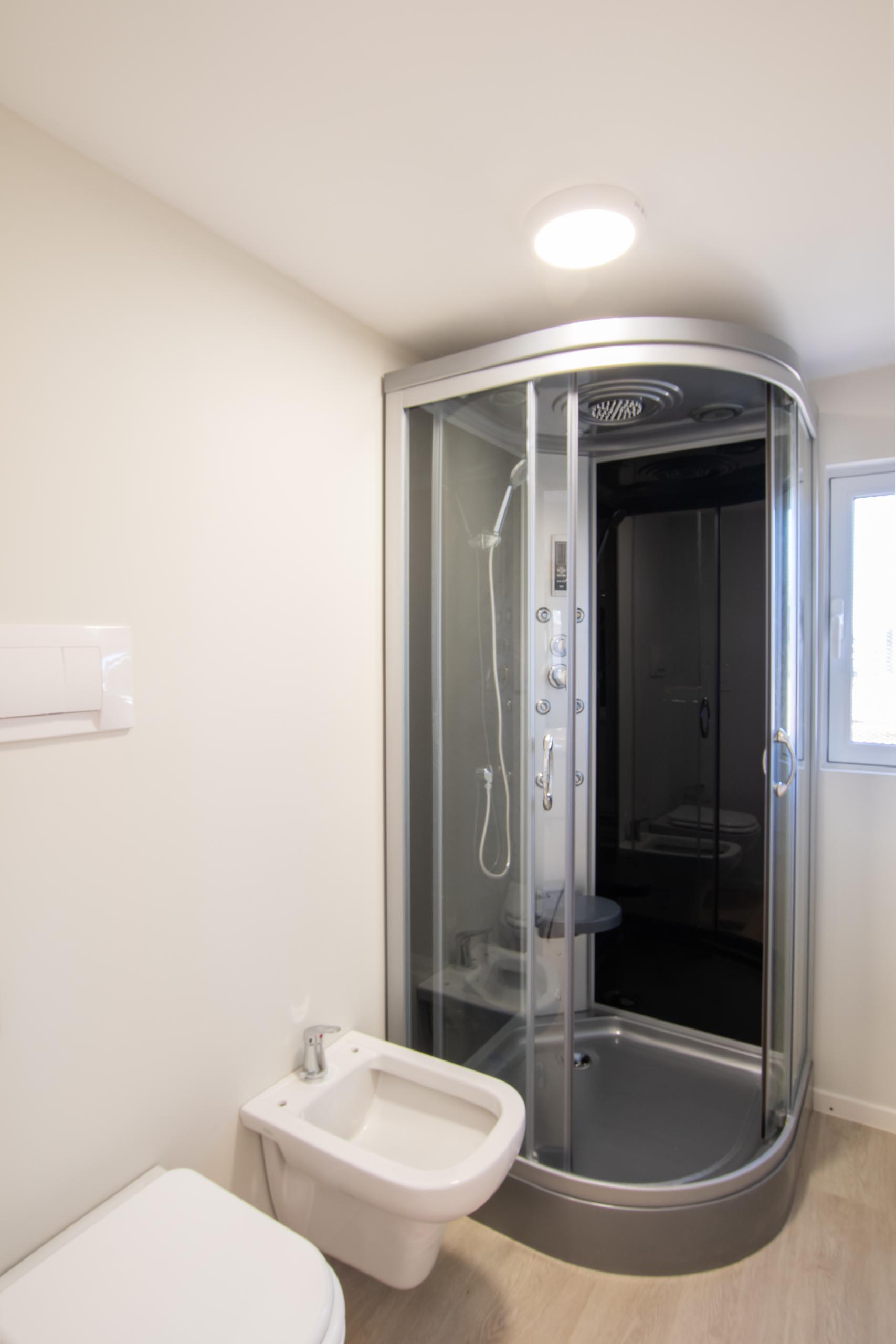 A modern tiny home with a toilet, bidet, and shower.