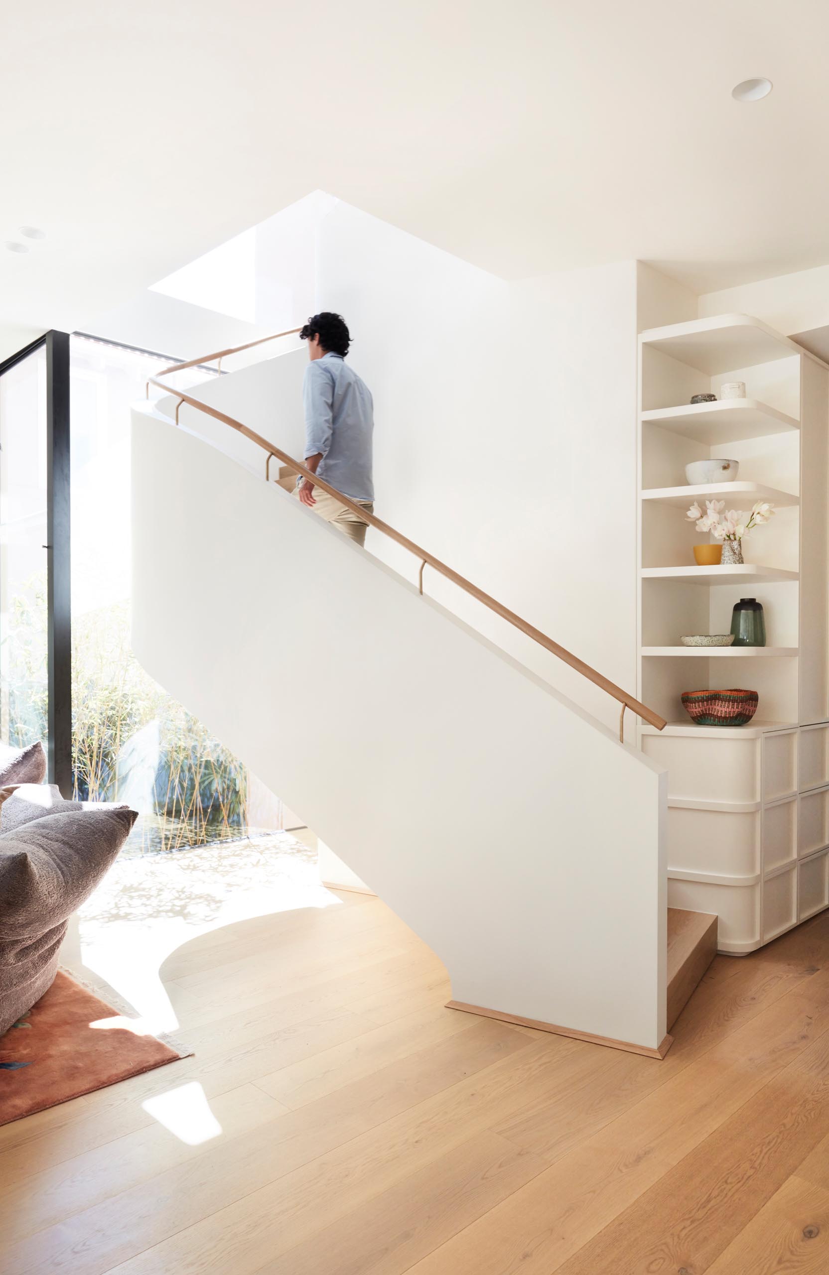 White stairs connect the living spaces with the bedrooms and bathrooms upstairs.