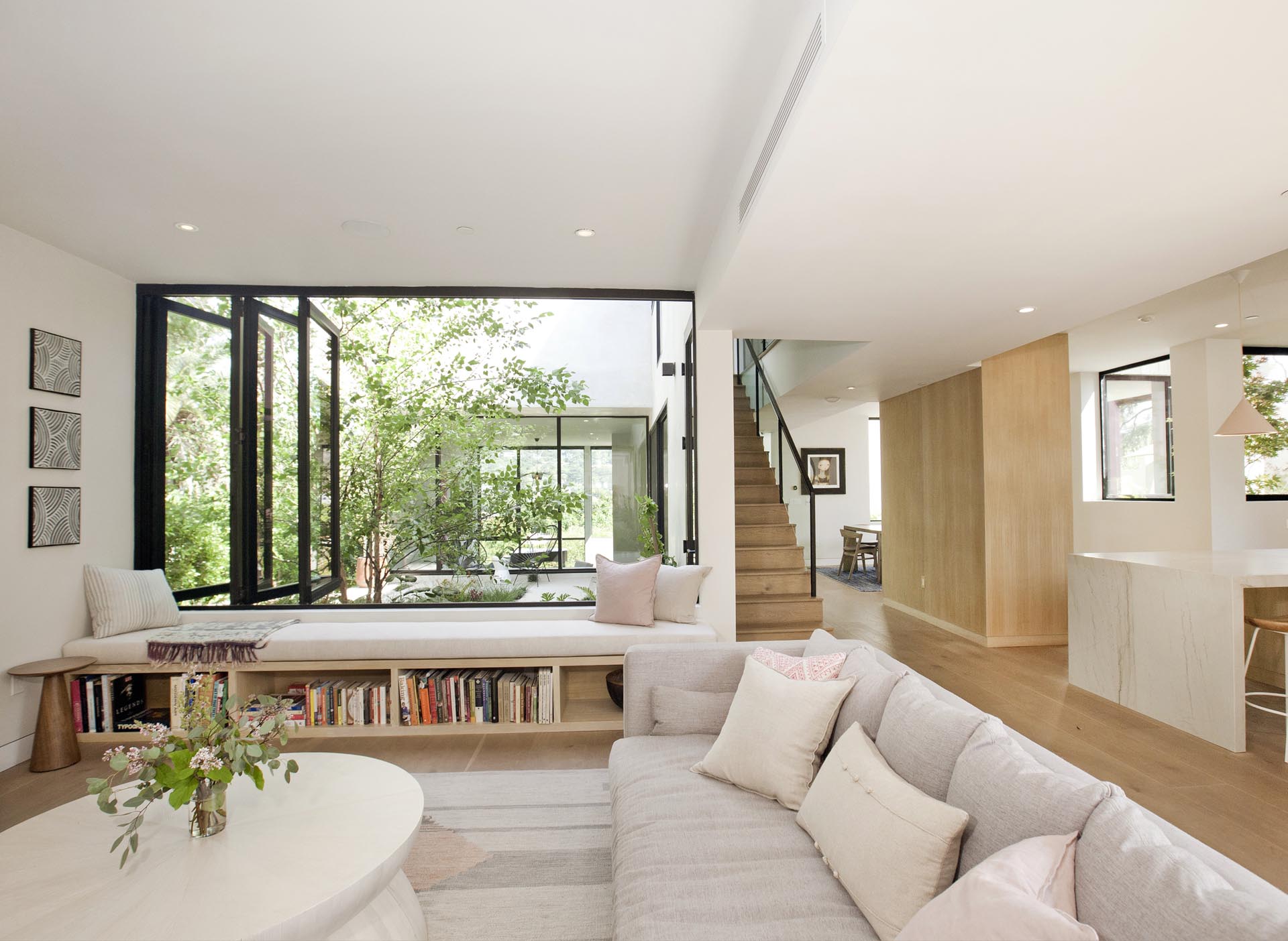 A modern window bench with a built-in bookshelf.