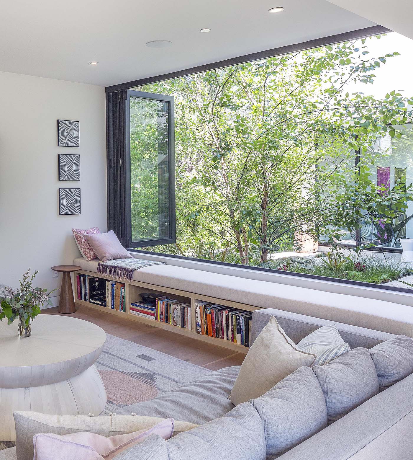 A modern window bench with a built-in bookshelf.