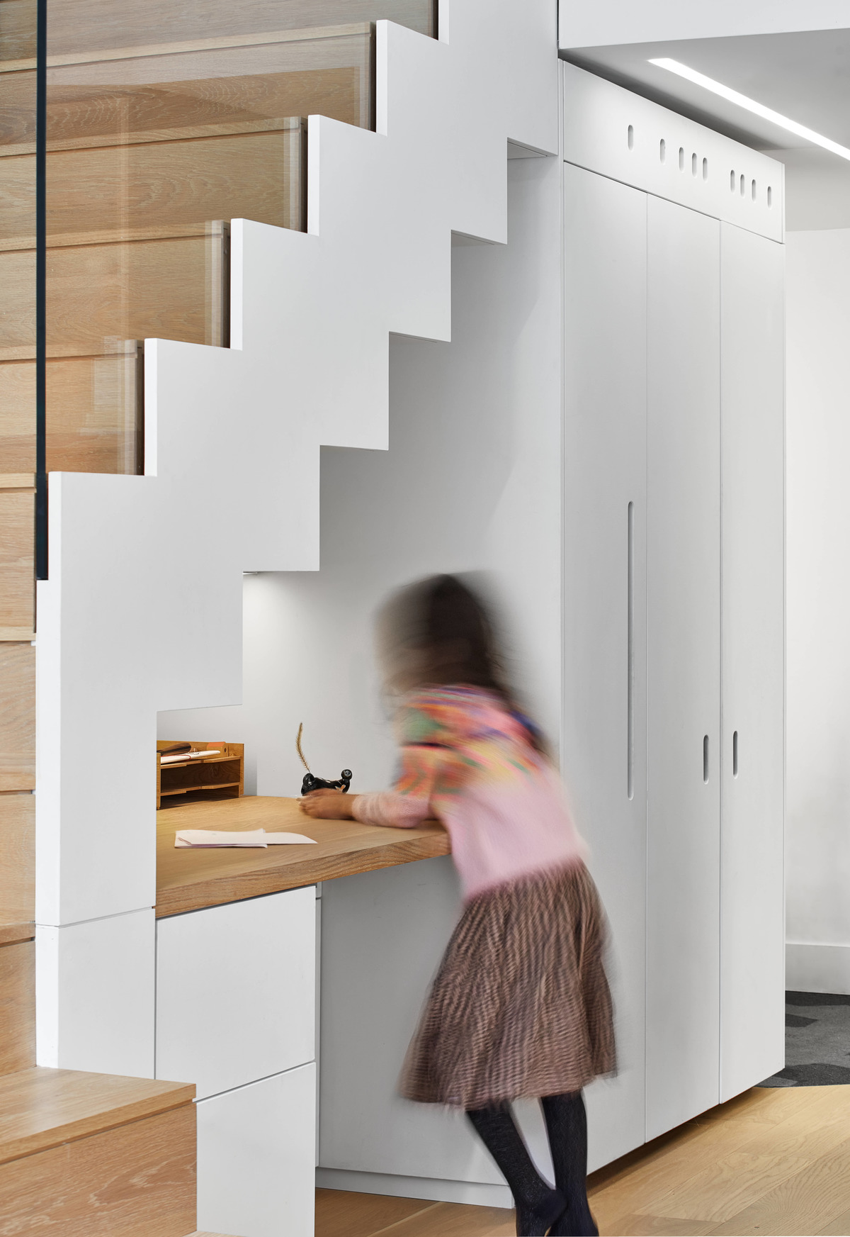 A built-in desk has been included underneath the stairs in a modern loft apartment.