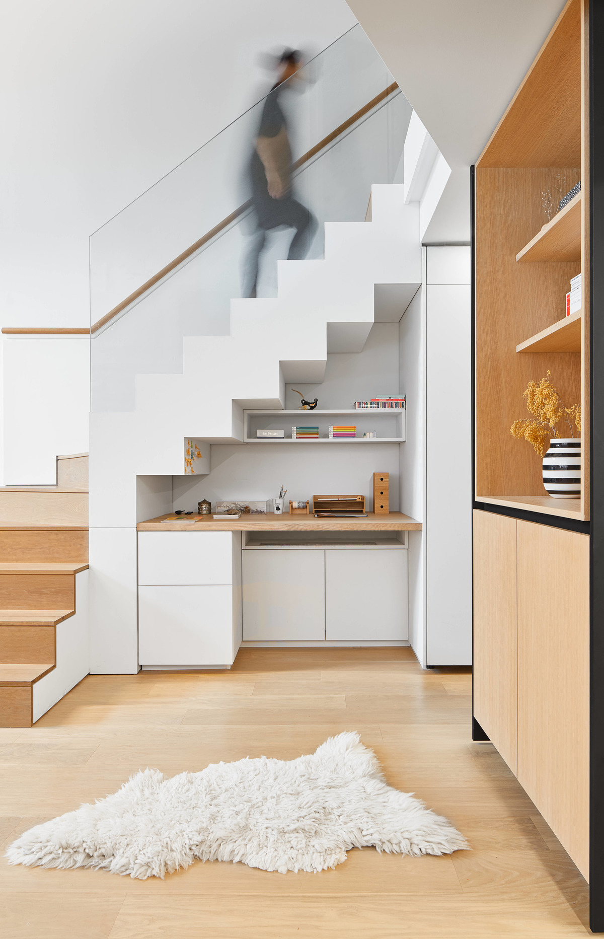 A modern desk has been built underneath the stairs of this loft apartment.