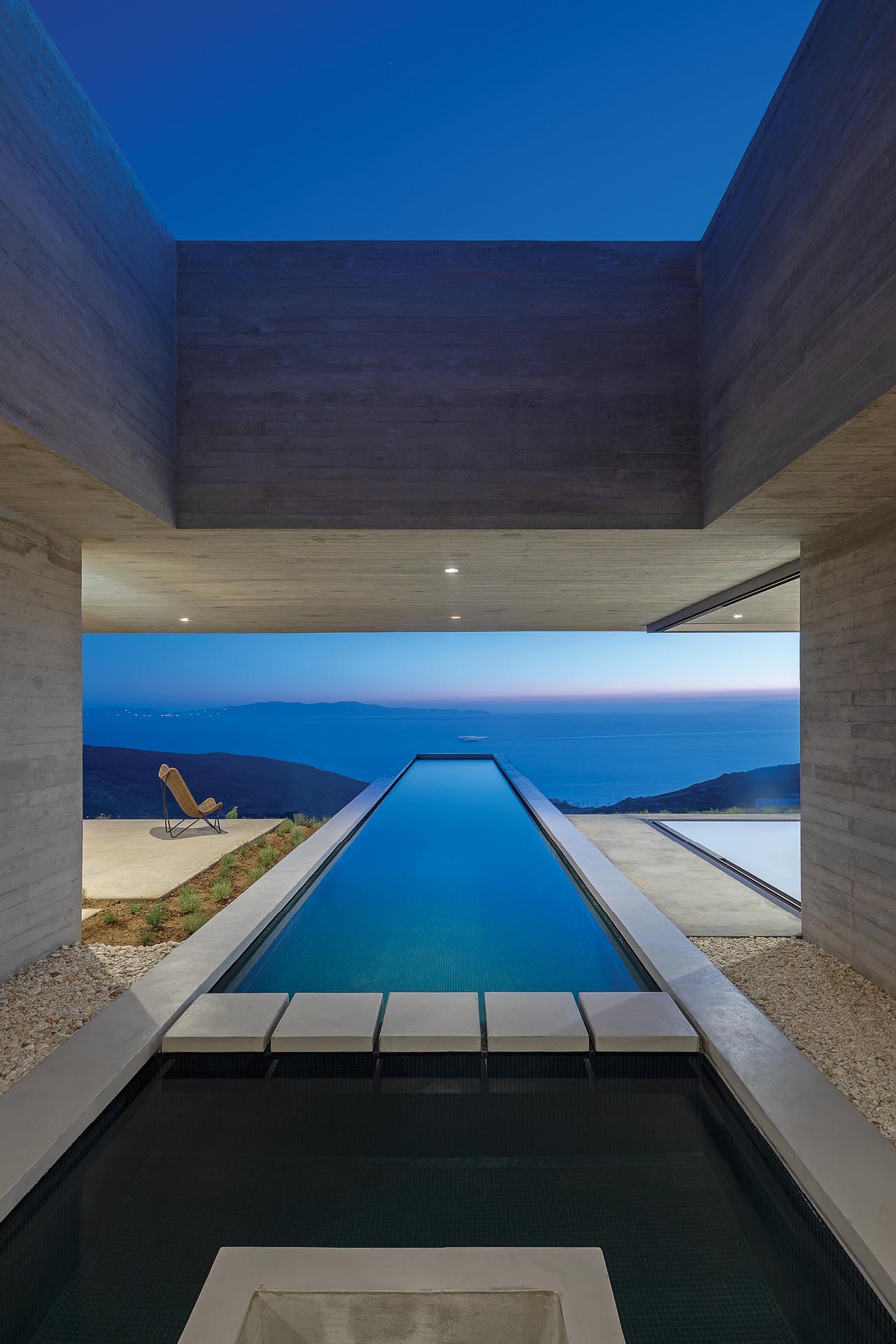 A modern concrete house with a linear swimming pool.