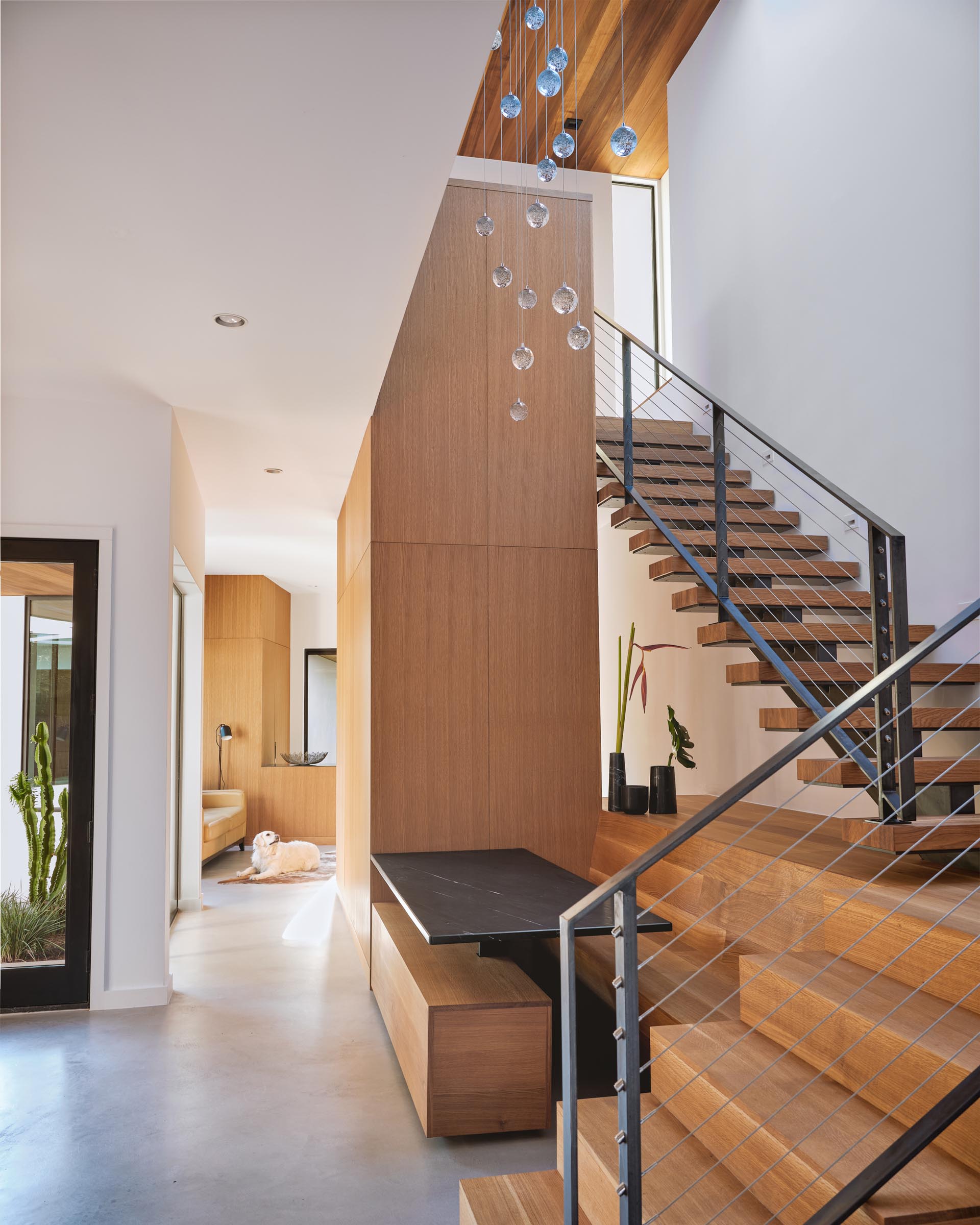 A modern dining area with a steel table and wood dining benches.