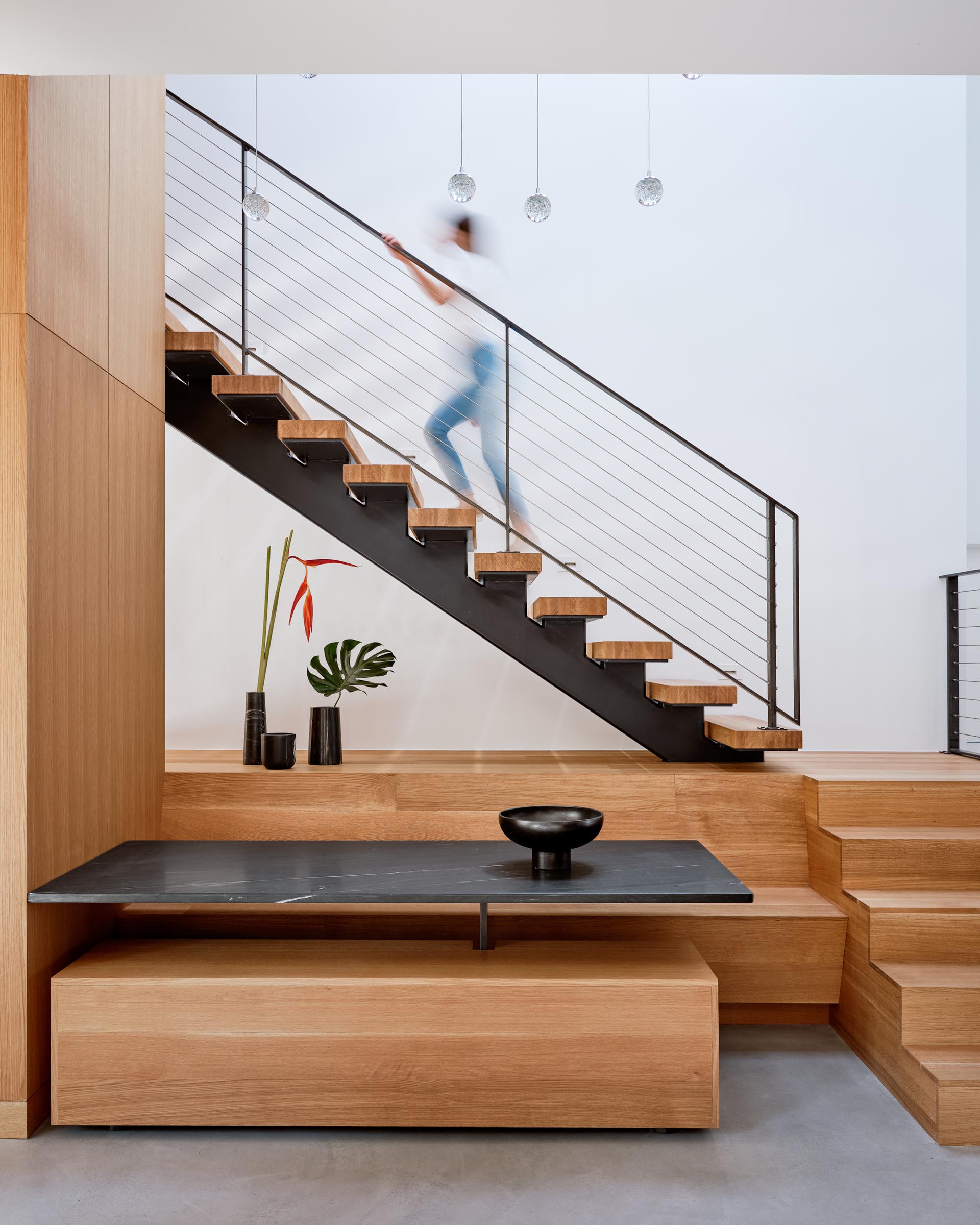 A modern built in dining area with benches and a dark table top.