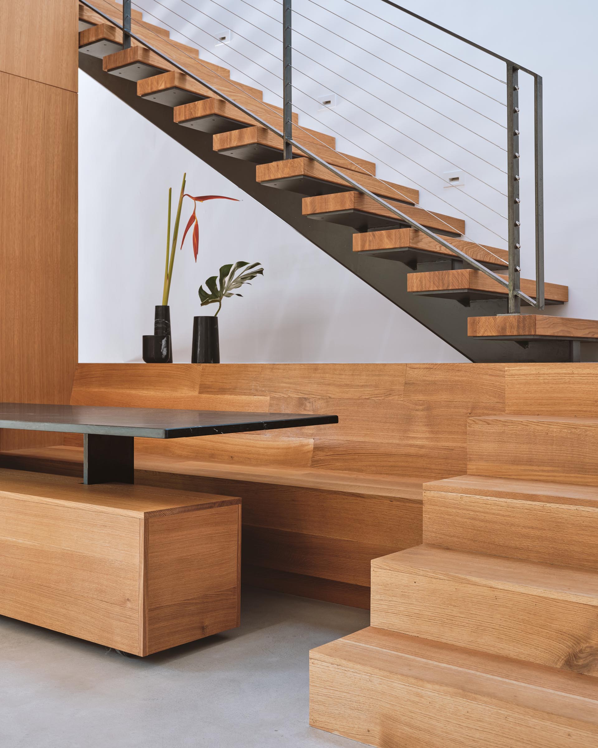 A modern built in dining area with benches and a dark table top.