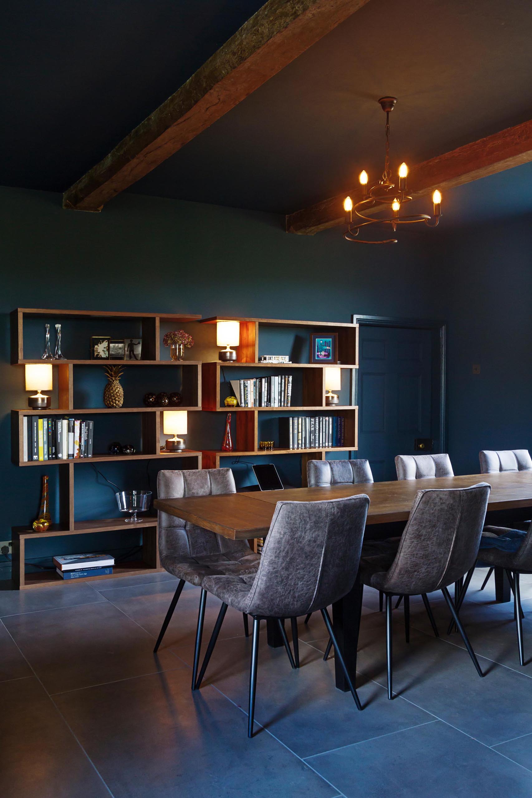 This formal dining room with exposed wood beams, acts as a way to connect a new addition to the original home.