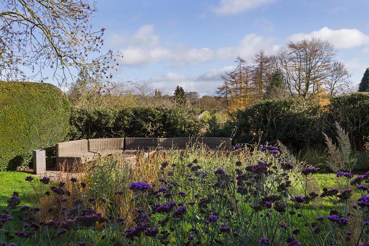 A large outdoor sofa tucked away into a garden.