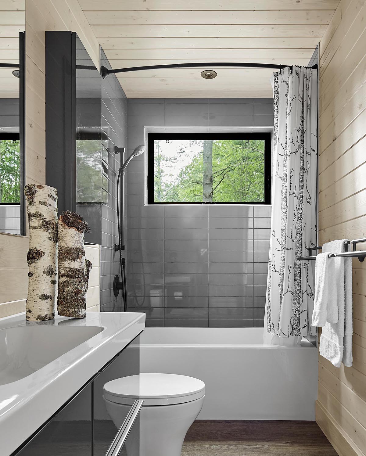 A modern gray and wood bathroom with black and white accents.