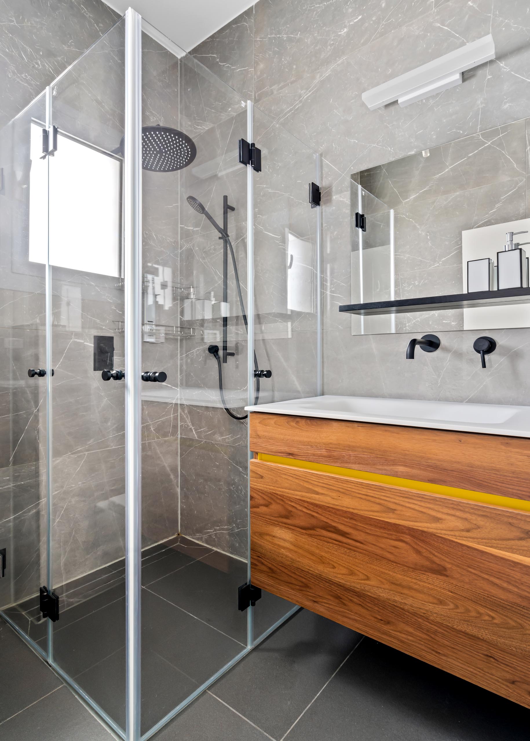 In this guest bathroom, there's a wood vanity with a simple yellow strip for a unique touch.