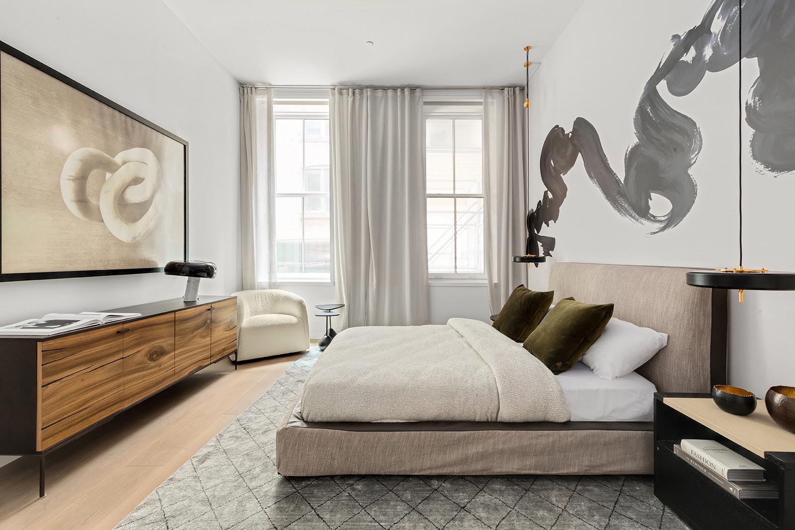 In this modern bedroom, large artwork has been used to fill the white walls.