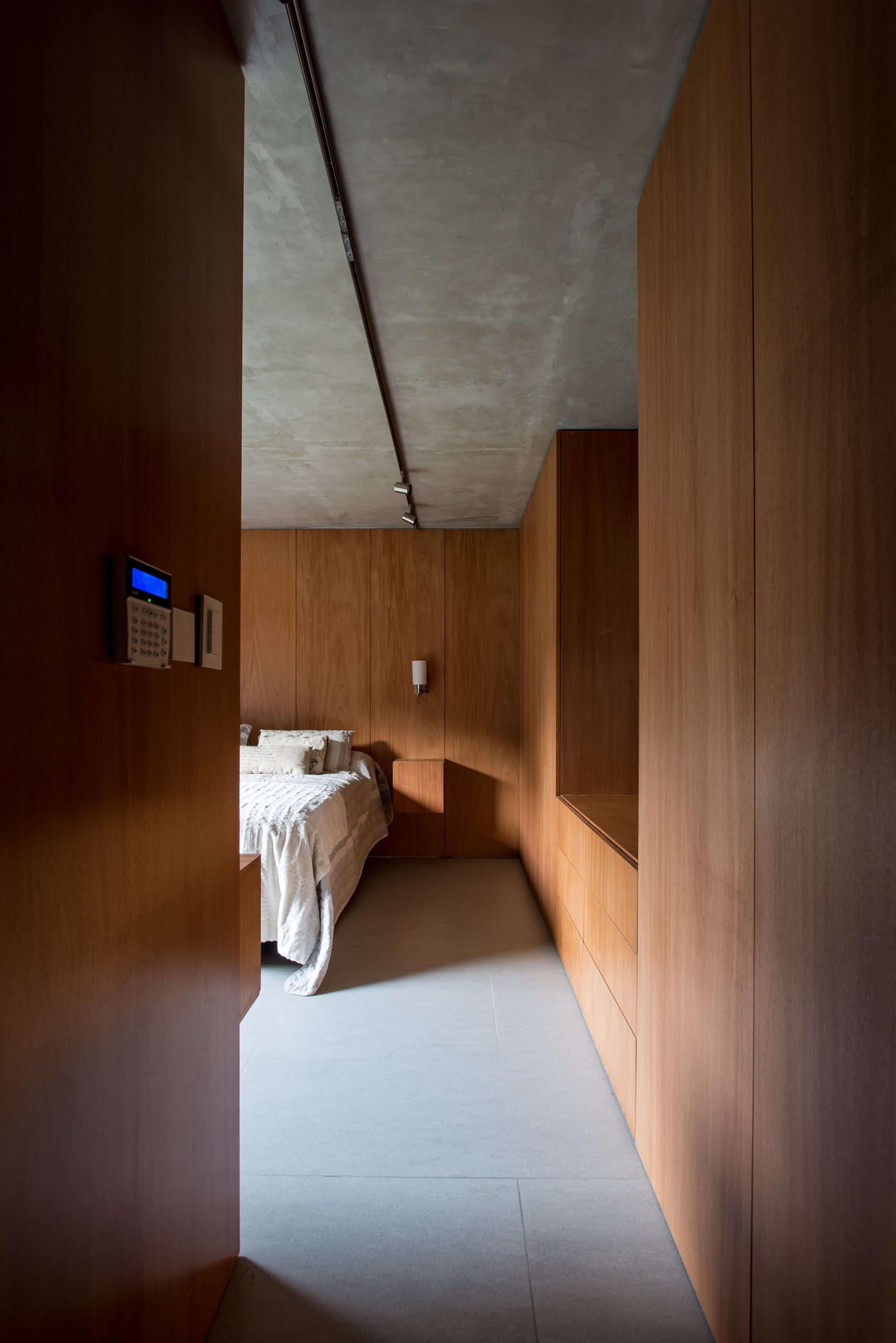 A modern bedroom with wood cabinets and accent walls.