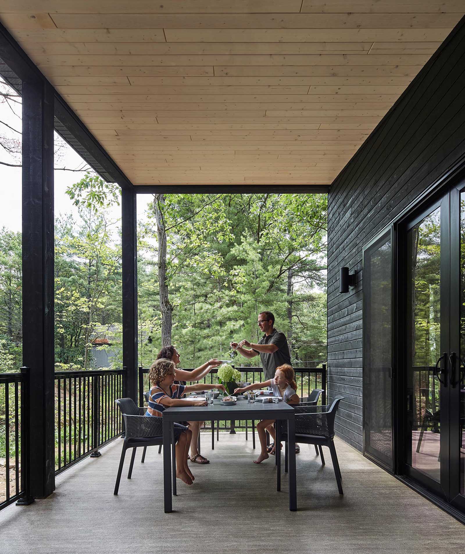 A modern cottage with a covered outdoor dining area.
