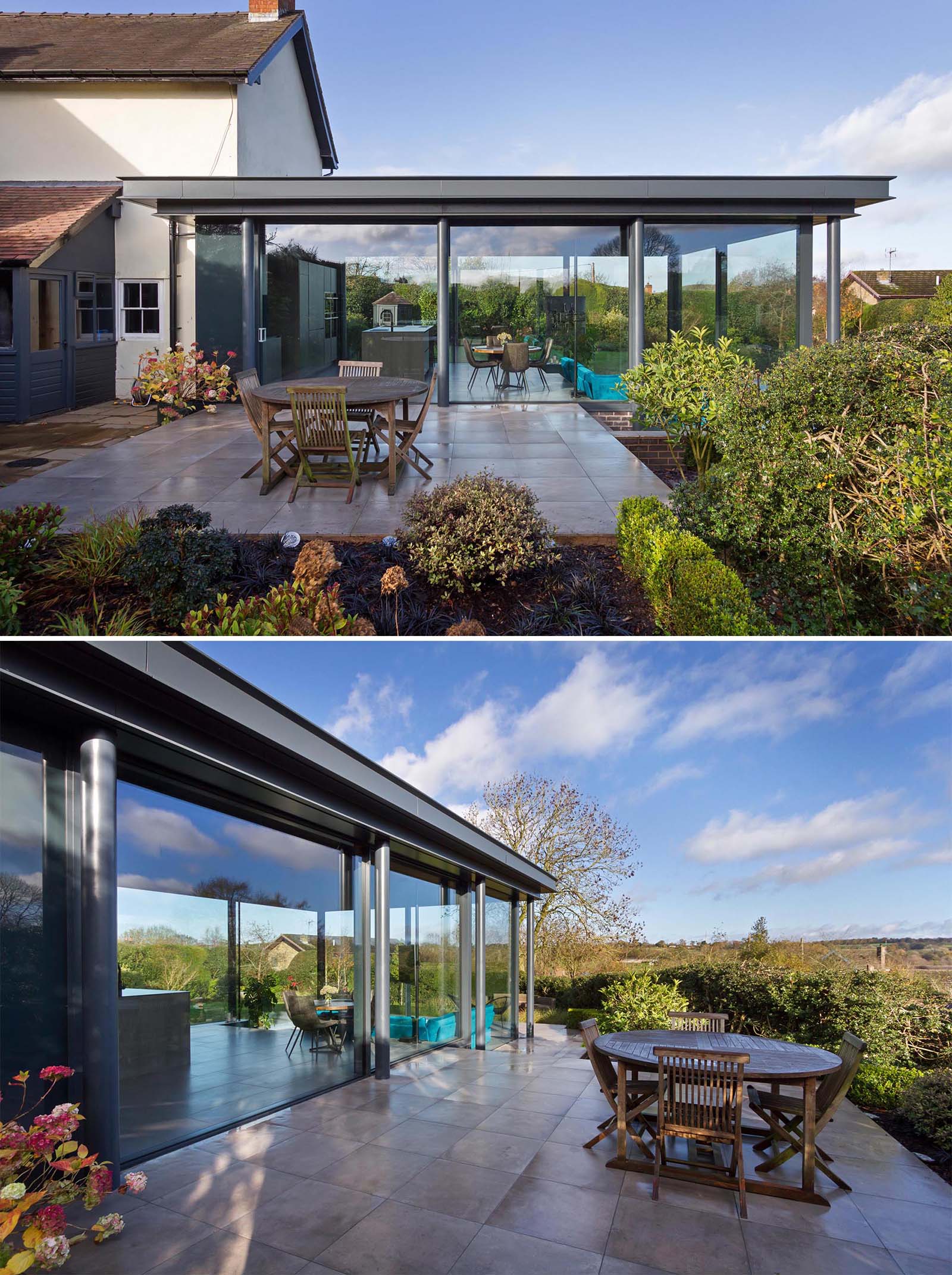 A modern home addition with glass walls has a patio that creates a space for outdoor dining, and connecting with the garden, where there's also an outdoor sofa for relaxing.