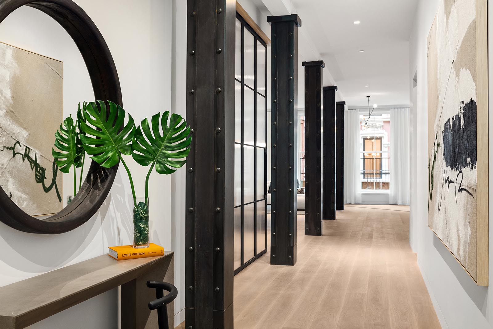 A wide hallway that showcases the steel beams, separates the living area from the sleeping quarters in this modern home.