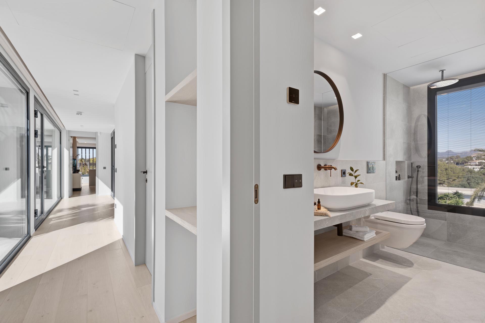 In this modern bathroom, there's a large window that provides tree views from the shower.