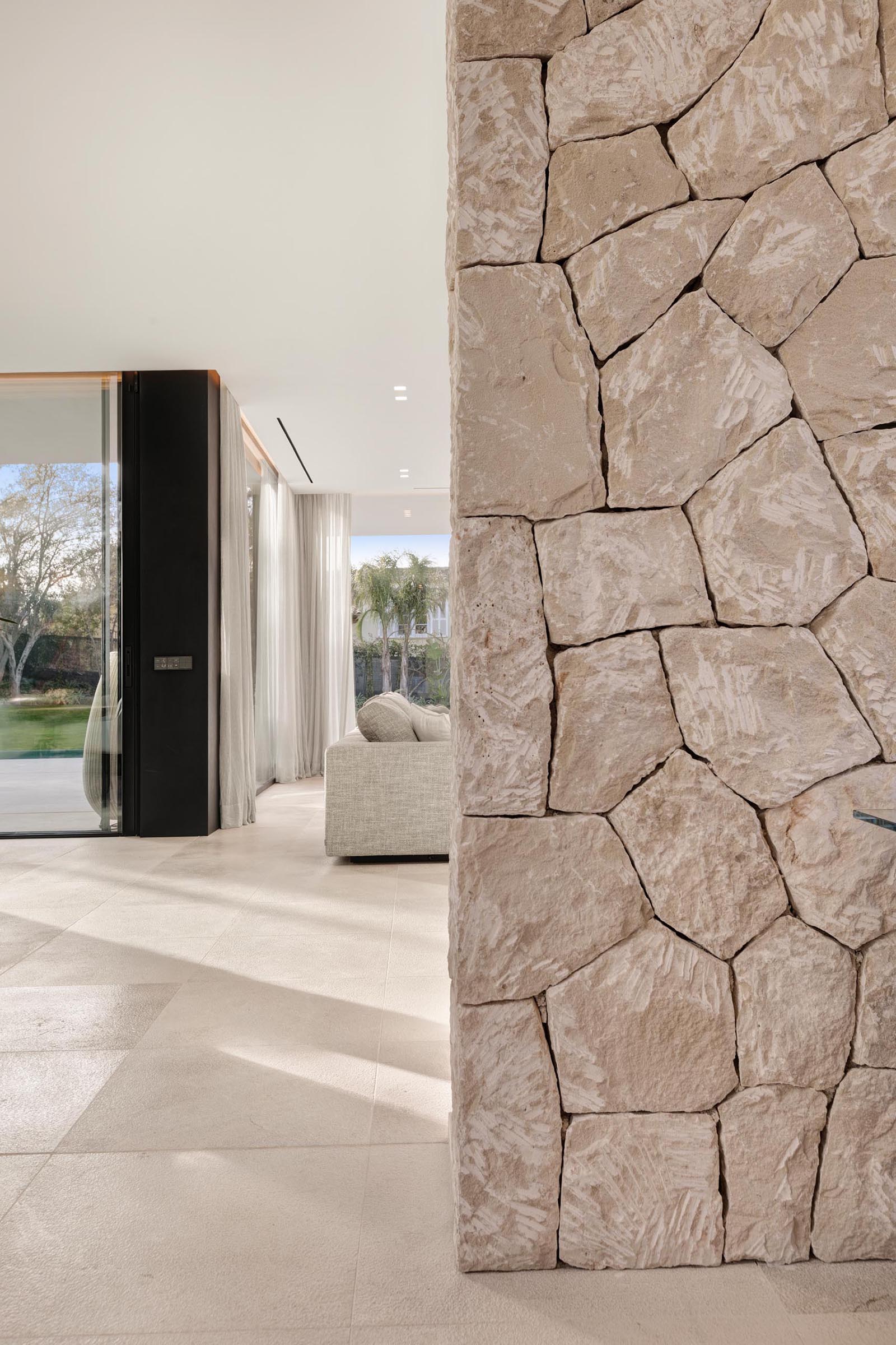 The local dry stone used on the exterior of this modern home, has also been introduced to the interior in the form of accent walls.