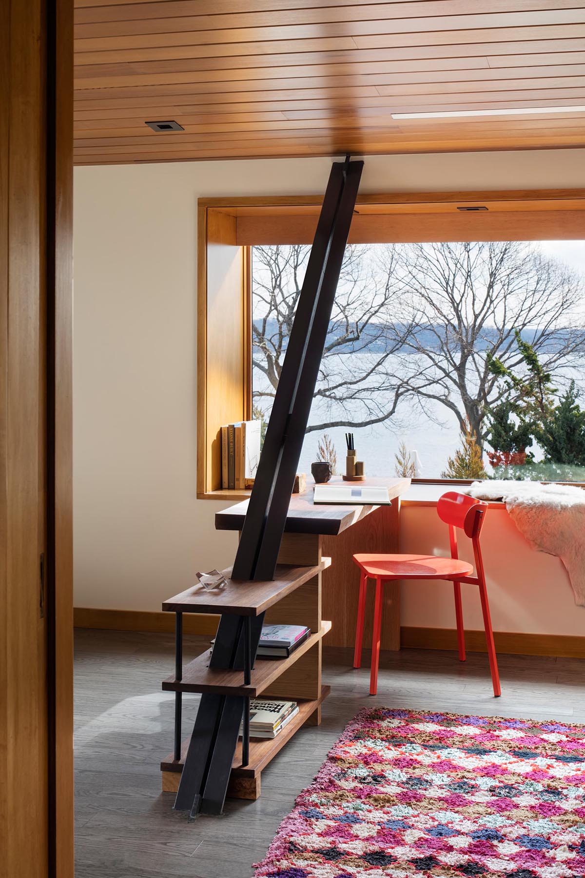 A home office has been created alongside a picture window and is flooded in natural light.