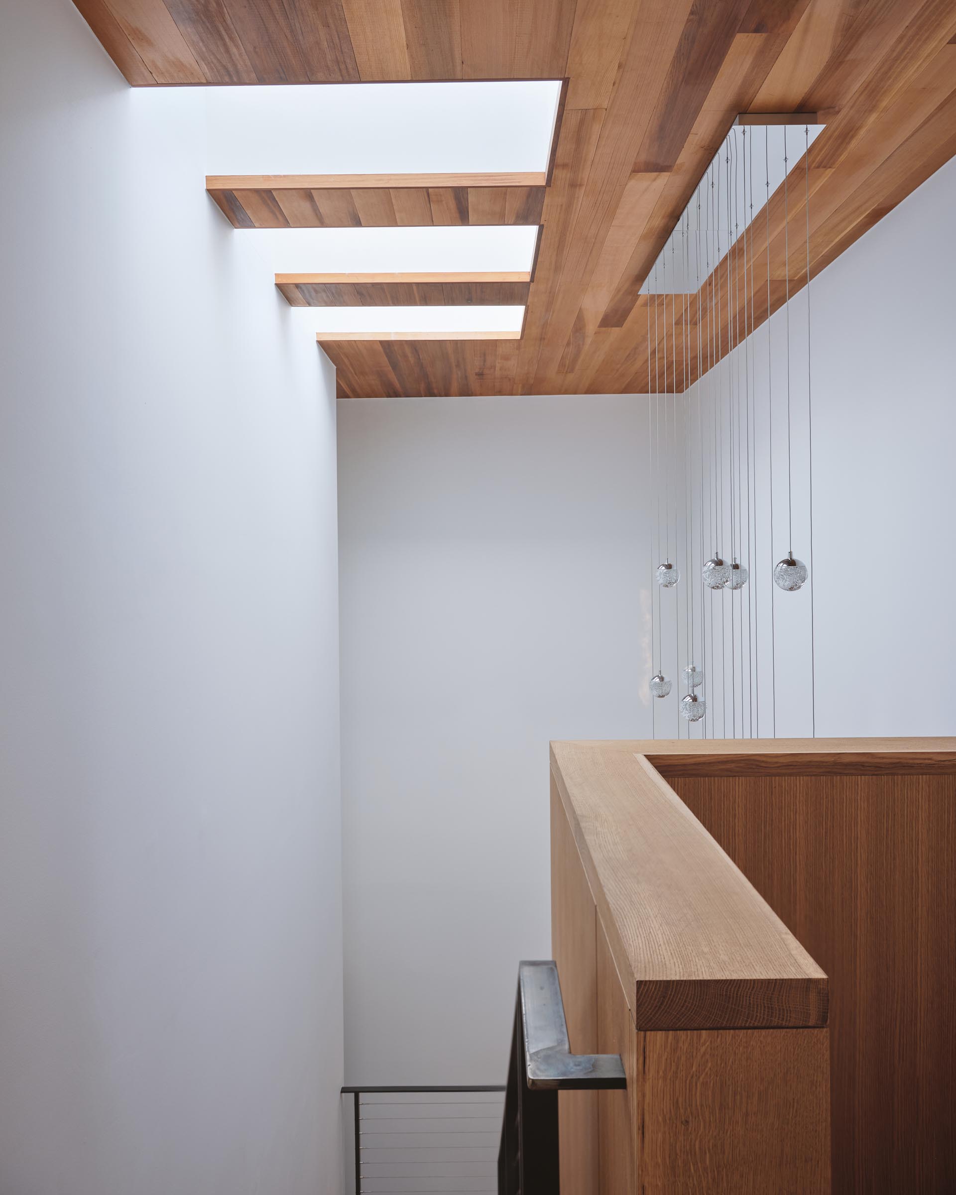 A modern wood ceiling with three skylights.