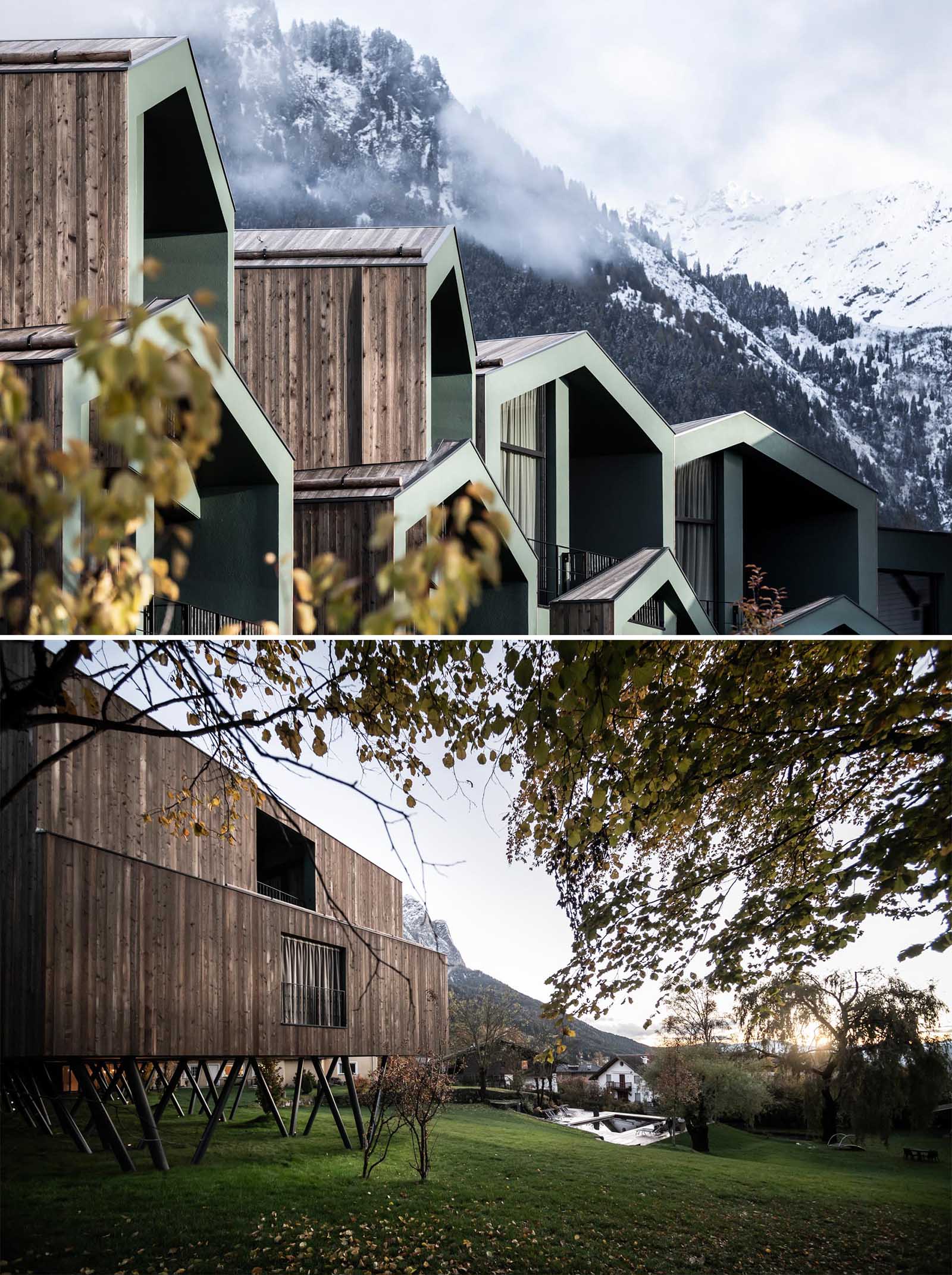 A collection of elevated hotel rooms with wood siding that are designed to look like tree houses.