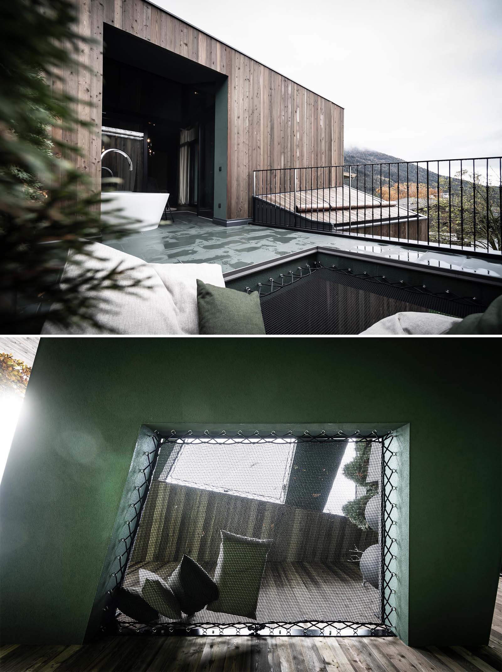 A modern hotel room with outdoor bathtub and a net seating area.