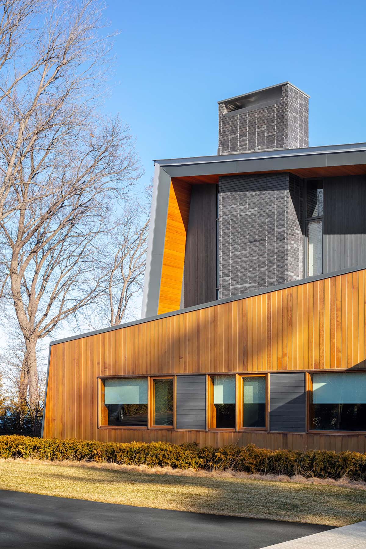 A modern house with a metal roof that wraps onto the walls of the home.