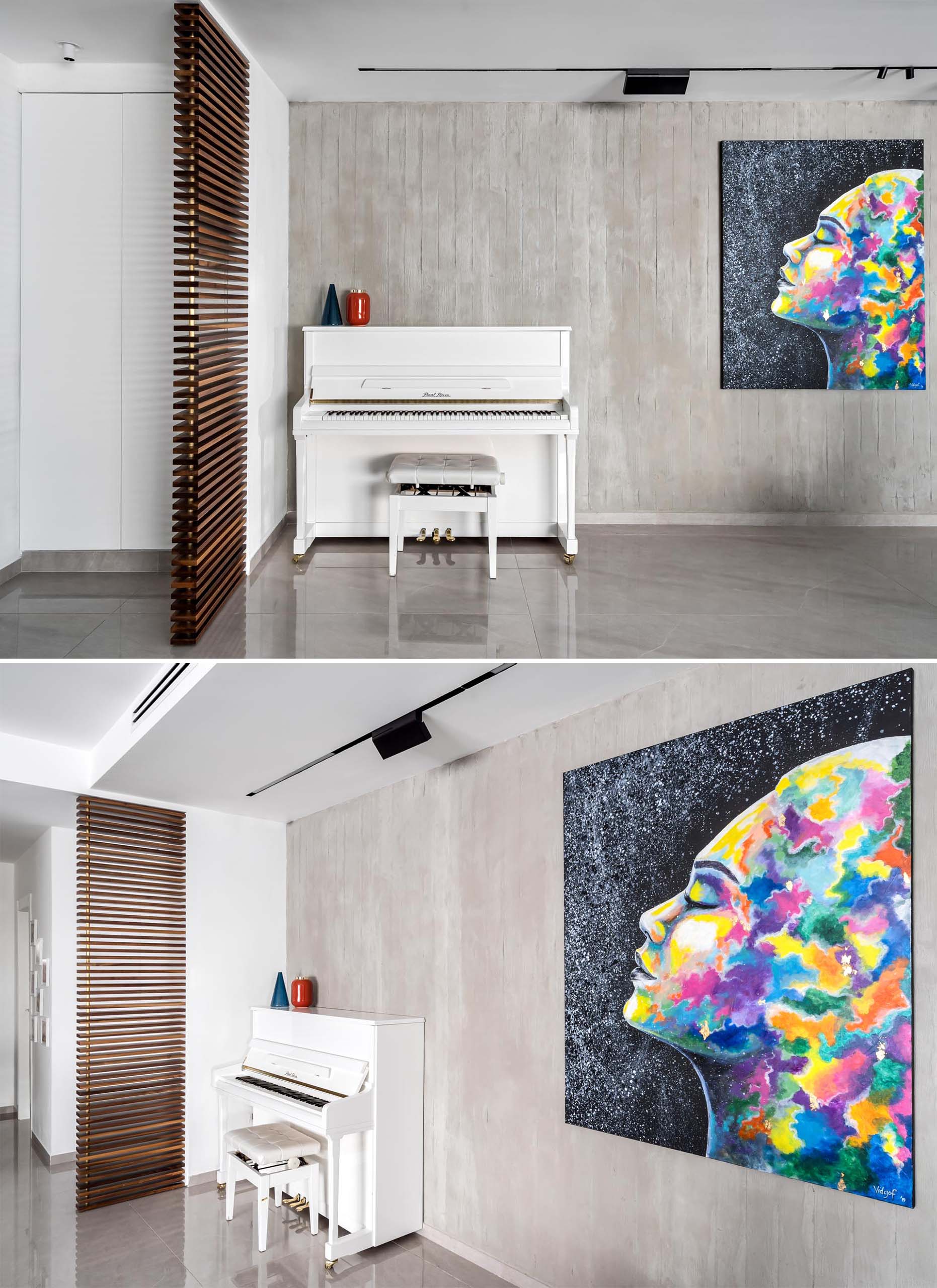 An exposed concrete wall decorated with a bold and colorful art piece.