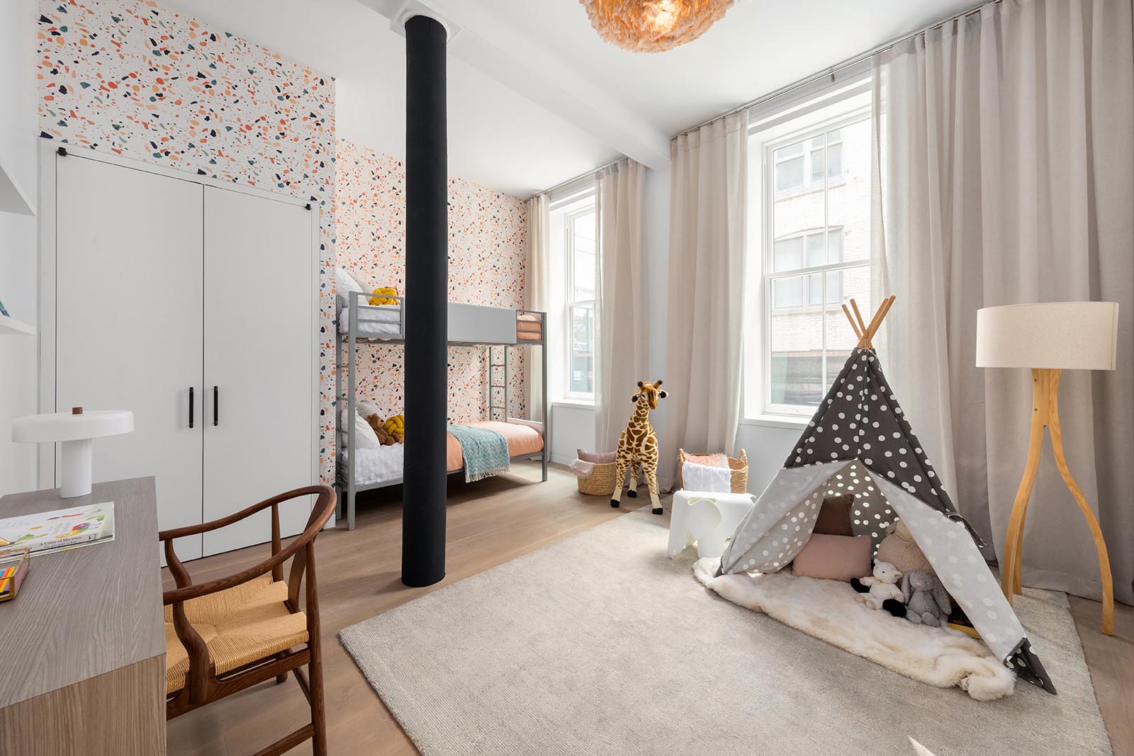 In this modern kid's bedroom, colorful wallpaper has been used to create a fun backdrop for the bunk beds, while the open space has been designated as a play area.