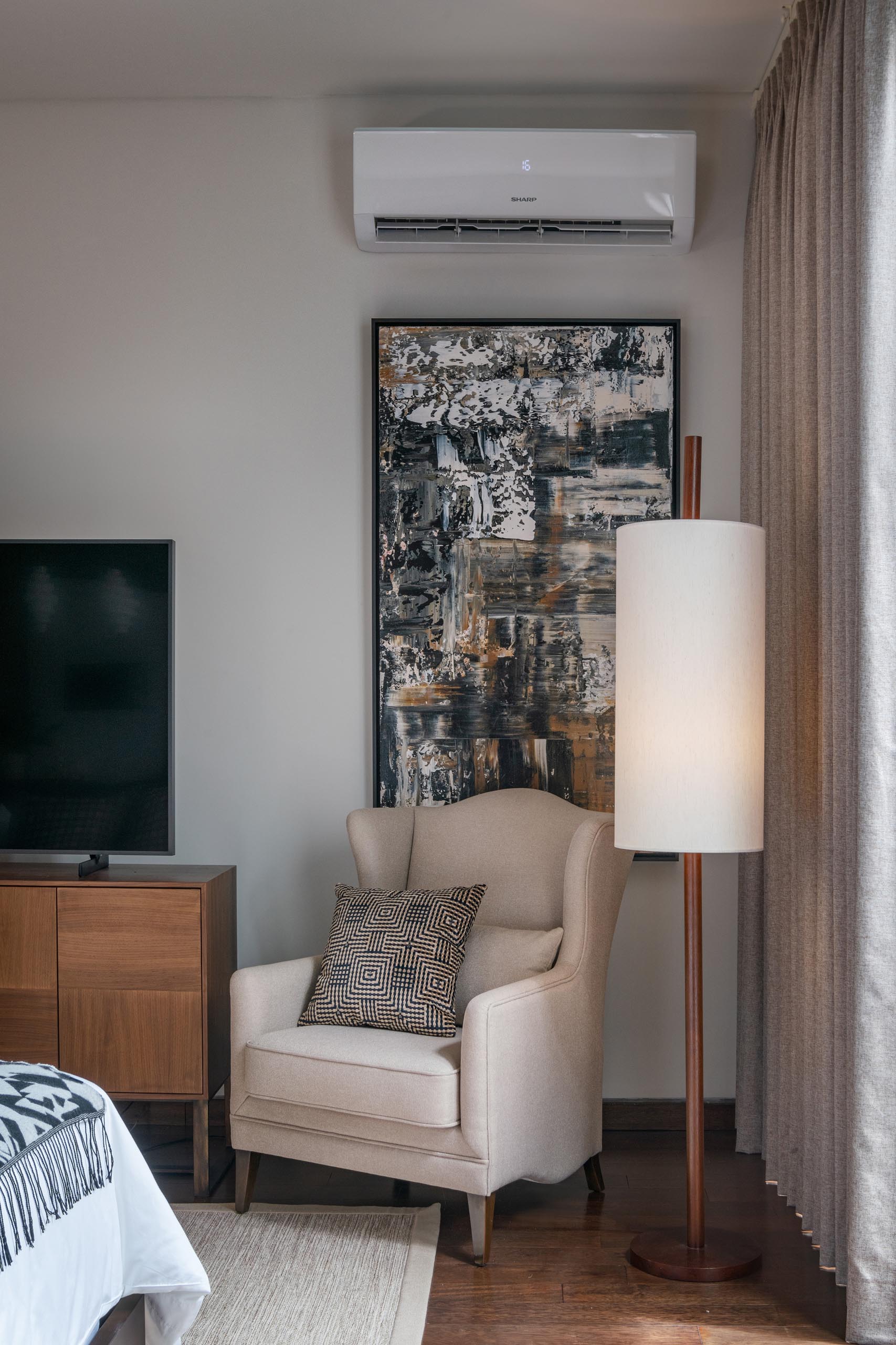 A contemporary bedroom with am armchair in the corner.