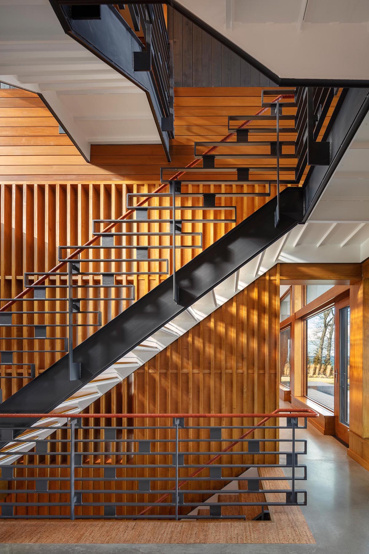 This modern staircase has a decorative metal railing as well as a leather wrapped handrail.