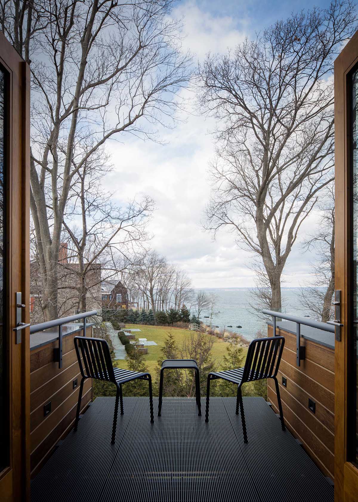 A modern cantilevered balcony accessed from a bedroom.