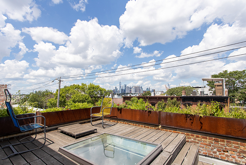 A rooftop deck with weathering steel planters.