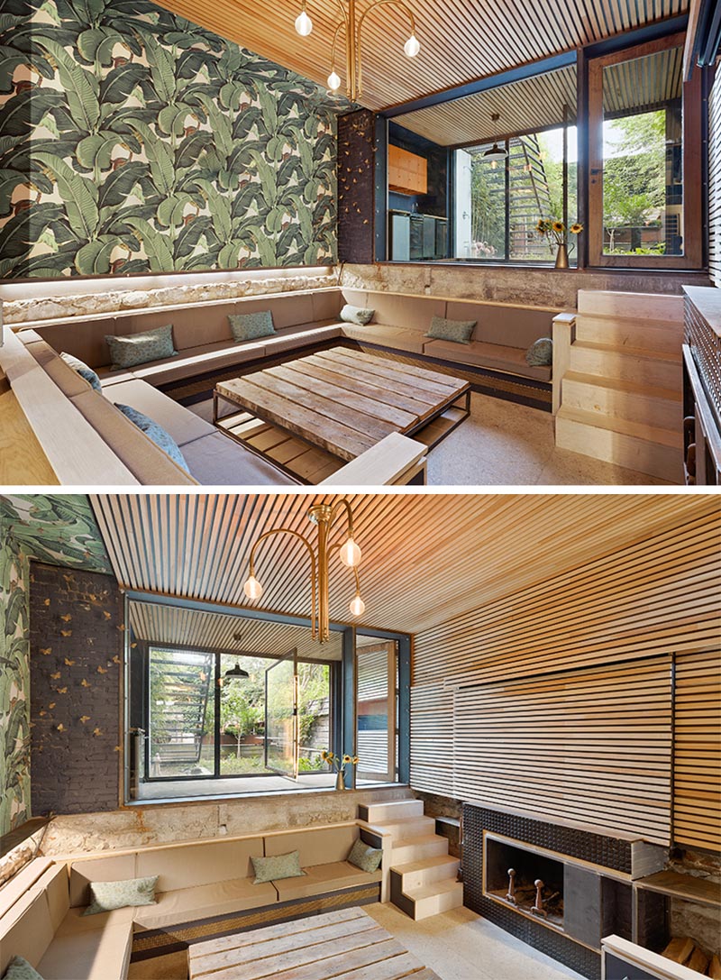 A sunken living room has been created on the lowest level of this home, and includes a wood ceiling that wraps around onto the wall, and extends outside. 