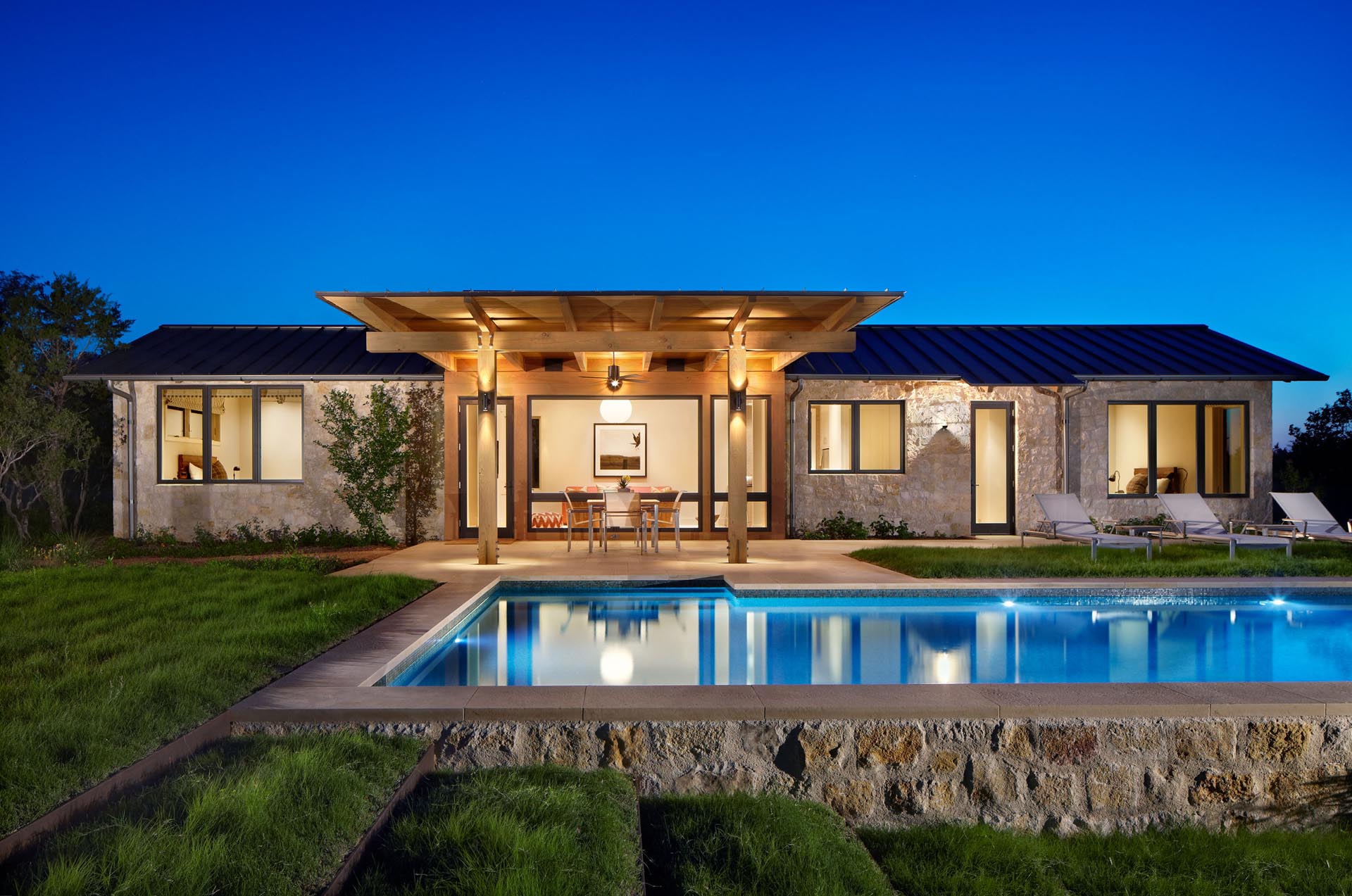 A guest house by the pool the includes a pair of bedrooms and an open plan living room and kitchen.