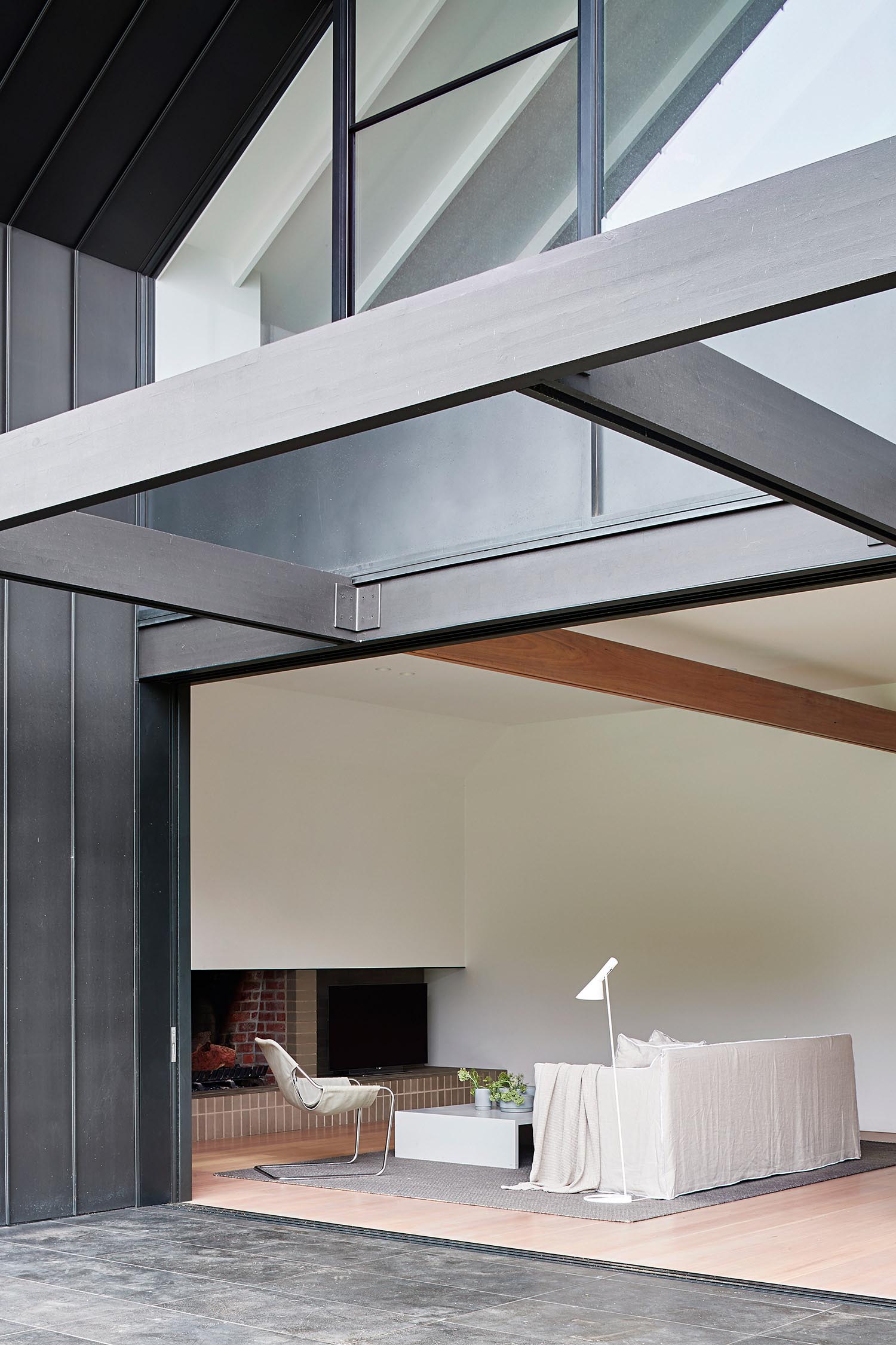 A living room with a modern brick fireplace and firewood storage.