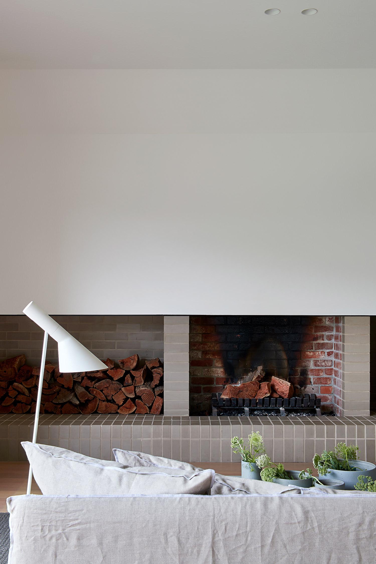 A modern brick fireplace with firewood storage.