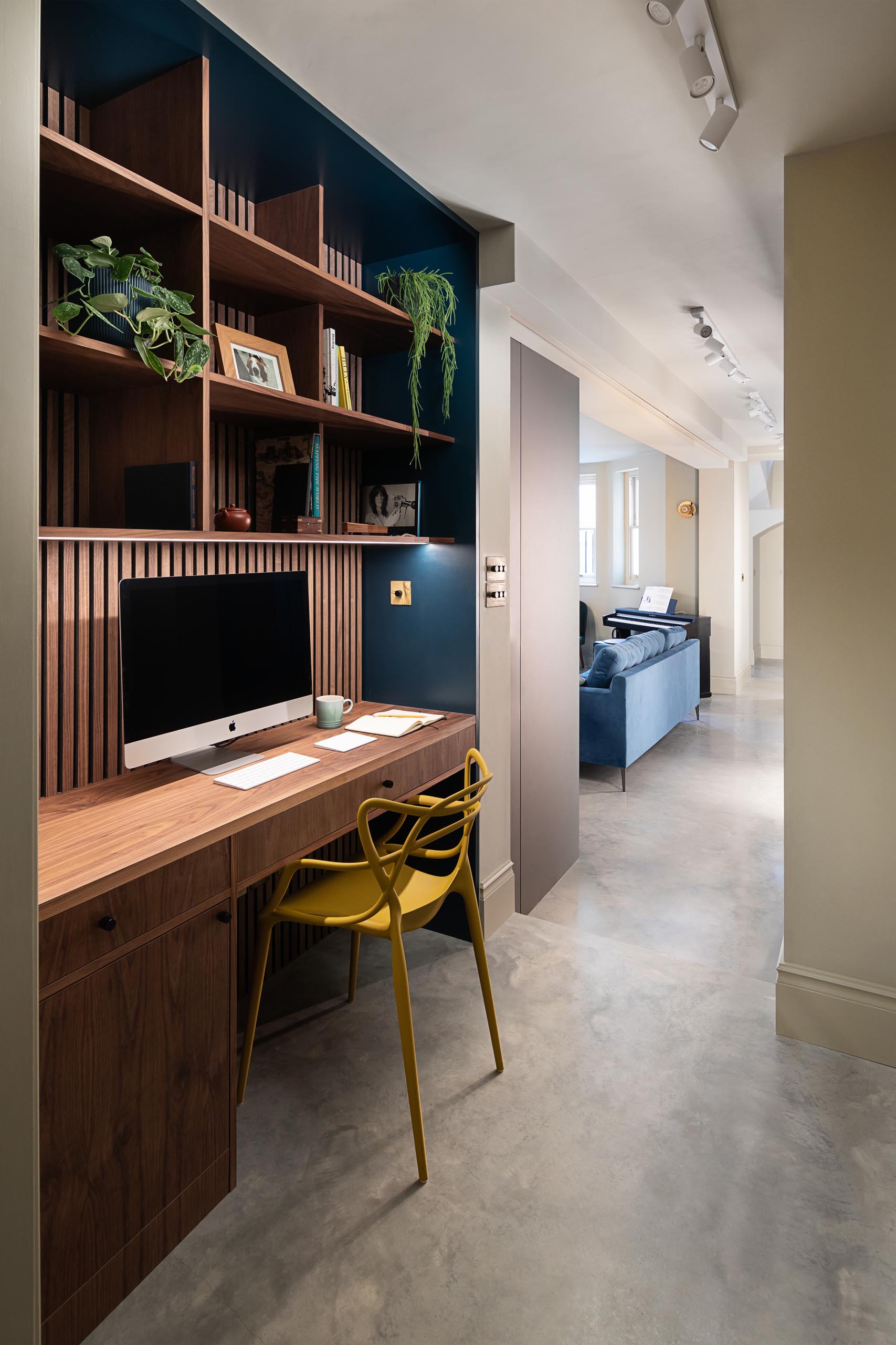 A modern apartment with a custom designed home office in the hallway.