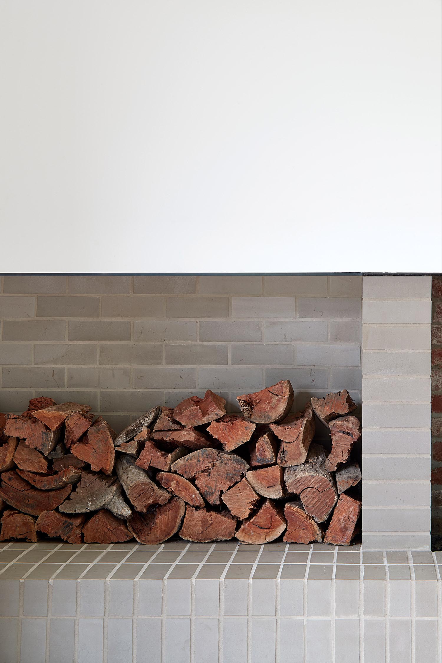 A modern brick fireplace with firewood storage.