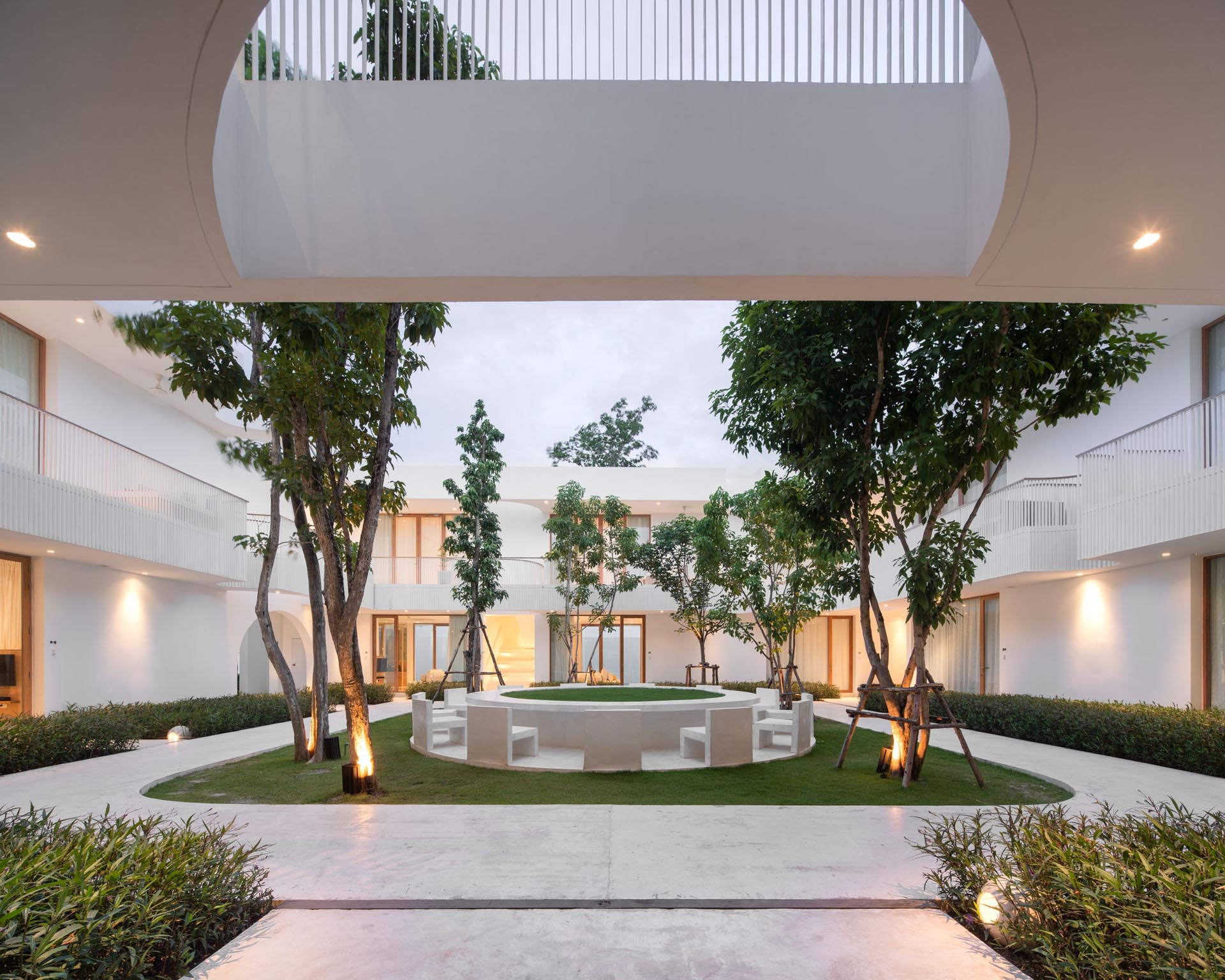 A modern hotel courtyard with outdoor chairs arranged in a circle.